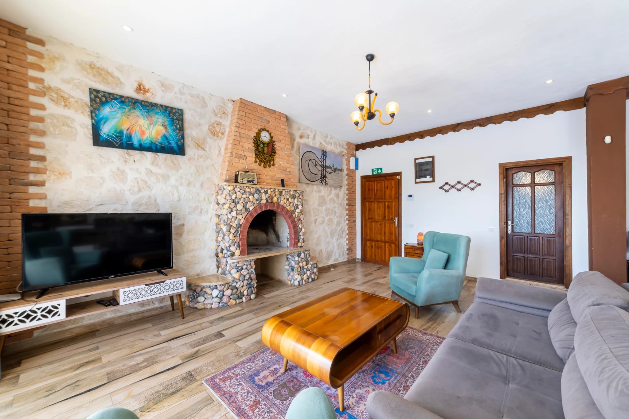 Cozy living room featuring a decorative fireplace with stone surround and entertainment setup.
