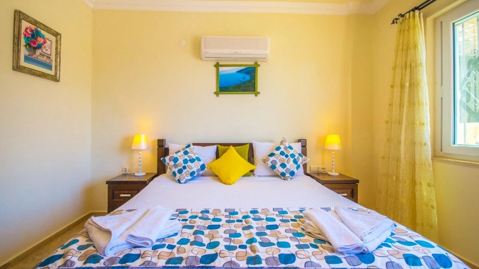Compact yellow bedroom with double bed and modern amenities.