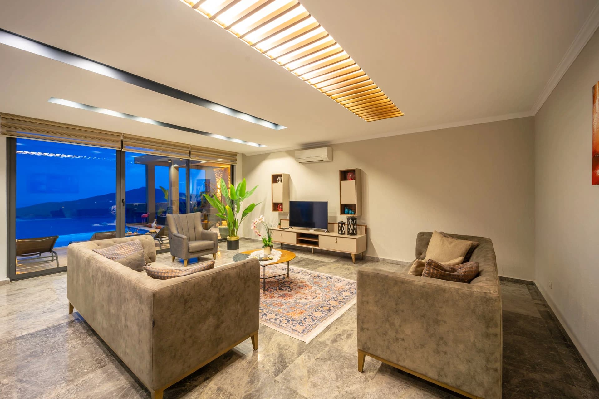 Sophisticated living room with contemporary furnishings and expansive evening sea views.
