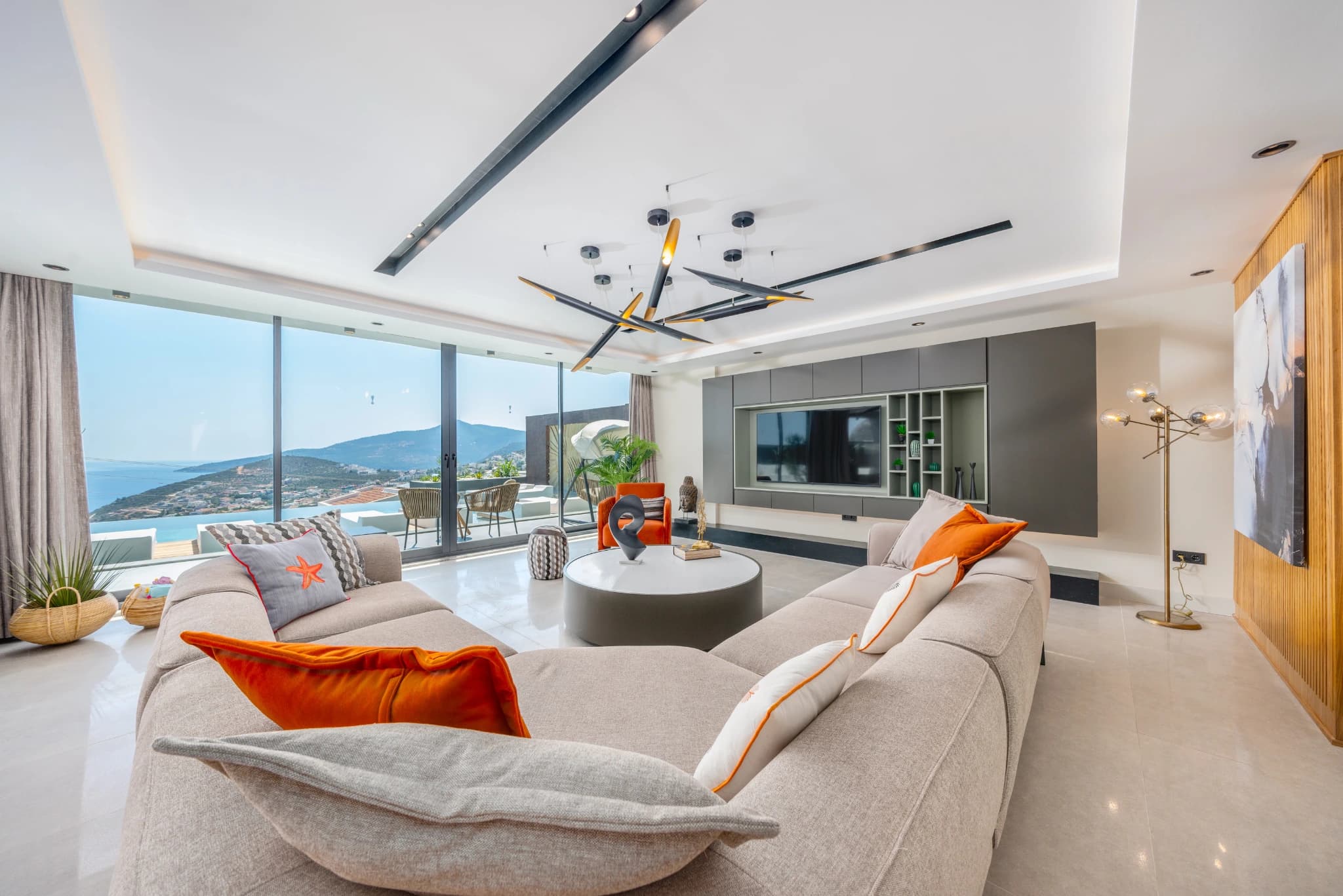 Luxury living room with wraparound seating, panoramic windows and coastal views.