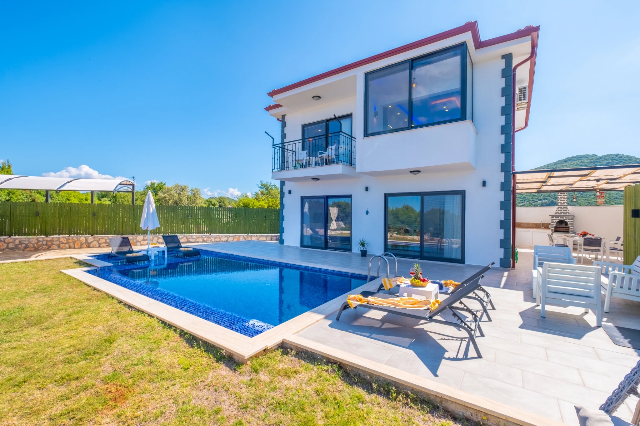 Modern villa with private pool, loungers, and manicured gardens.