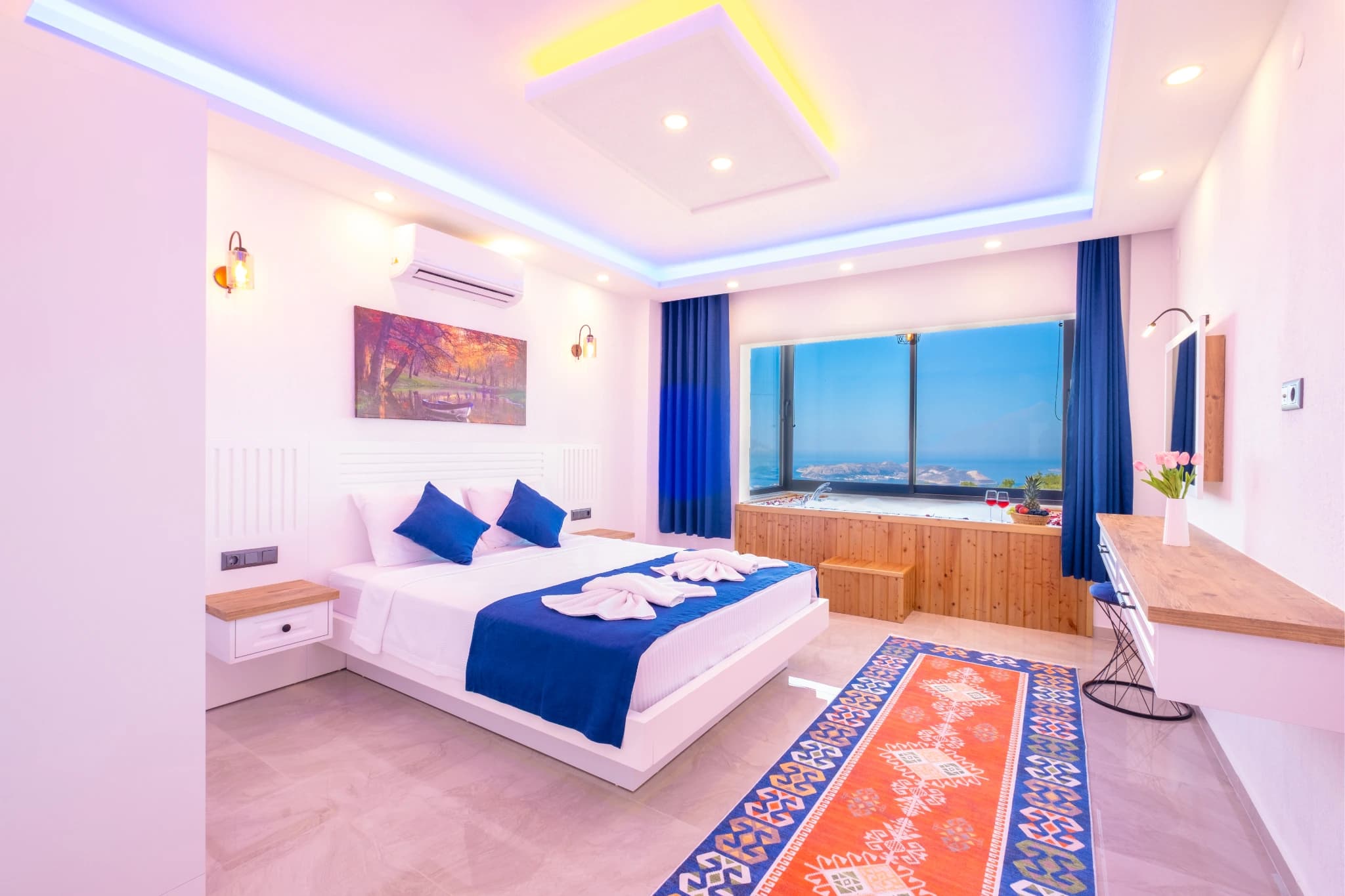 Luxurious master bedroom with sea view, king bed, and colorful accent lighting.