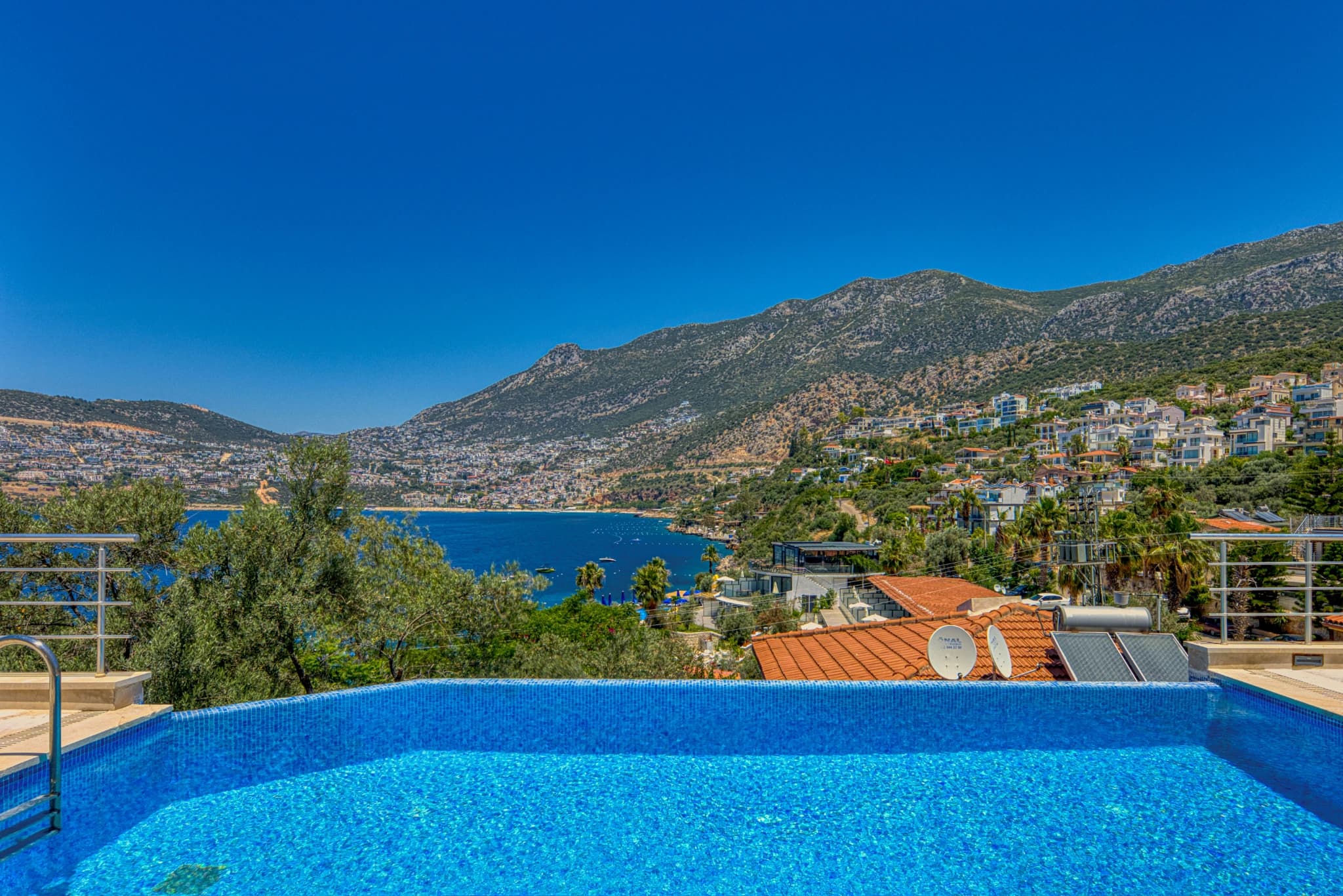 Elevated pool view overlooking the bay and coastal town.