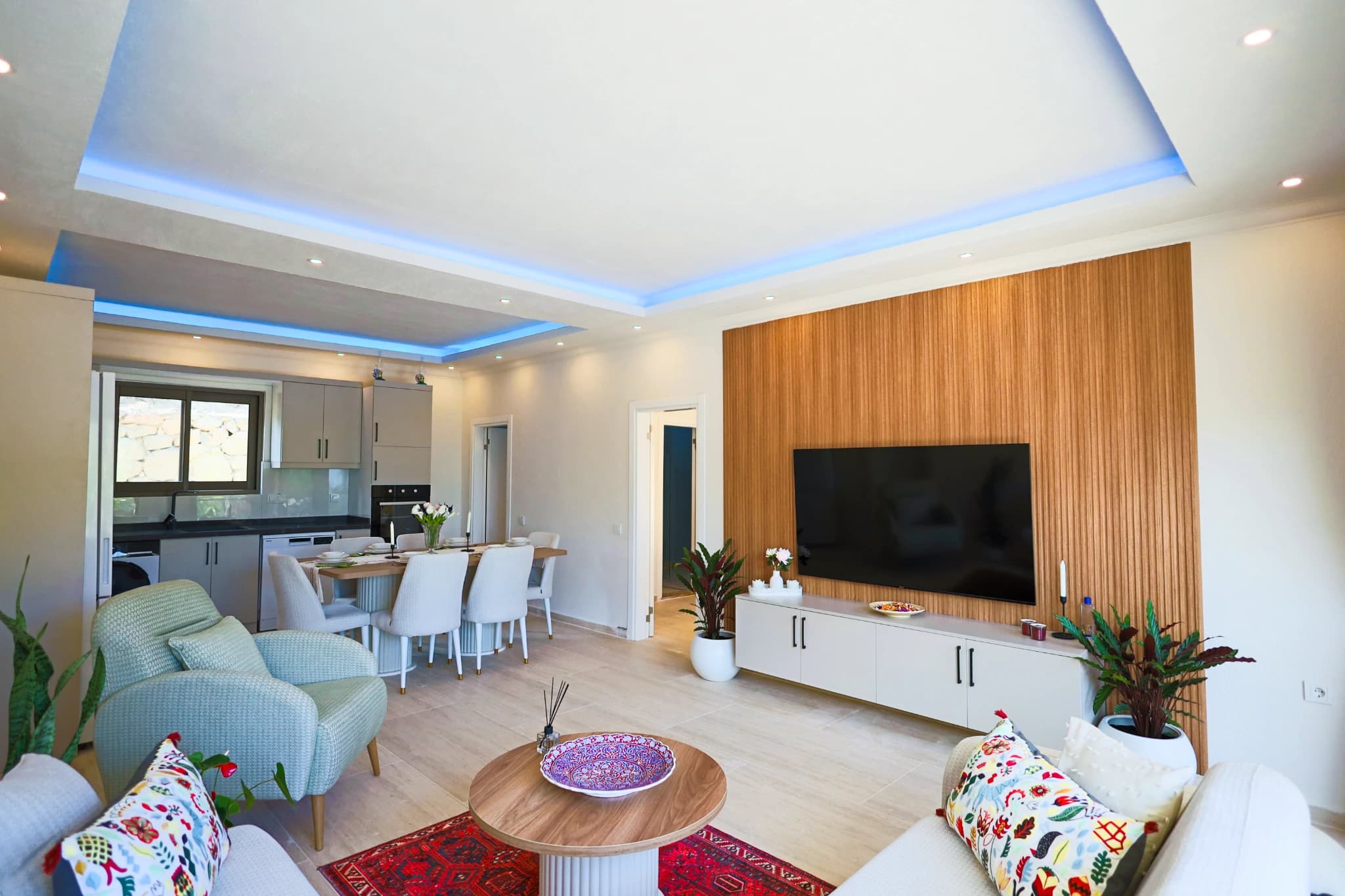 Open-plan living room with smart TV, comfortable seating, and integrated dining area.