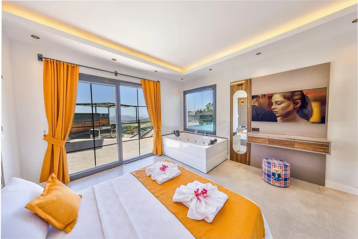 Luxury bedroom with integrated spa, television, and direct access to pool terrace.