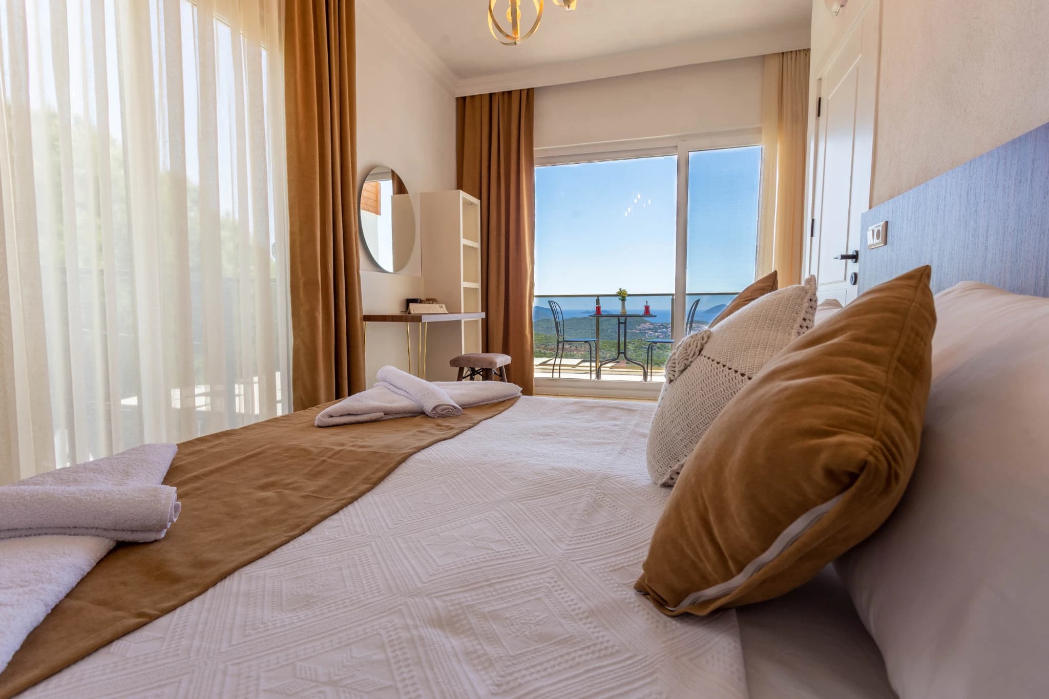 Spacious bedroom with dual queen beds and panoramic sea view balcony.