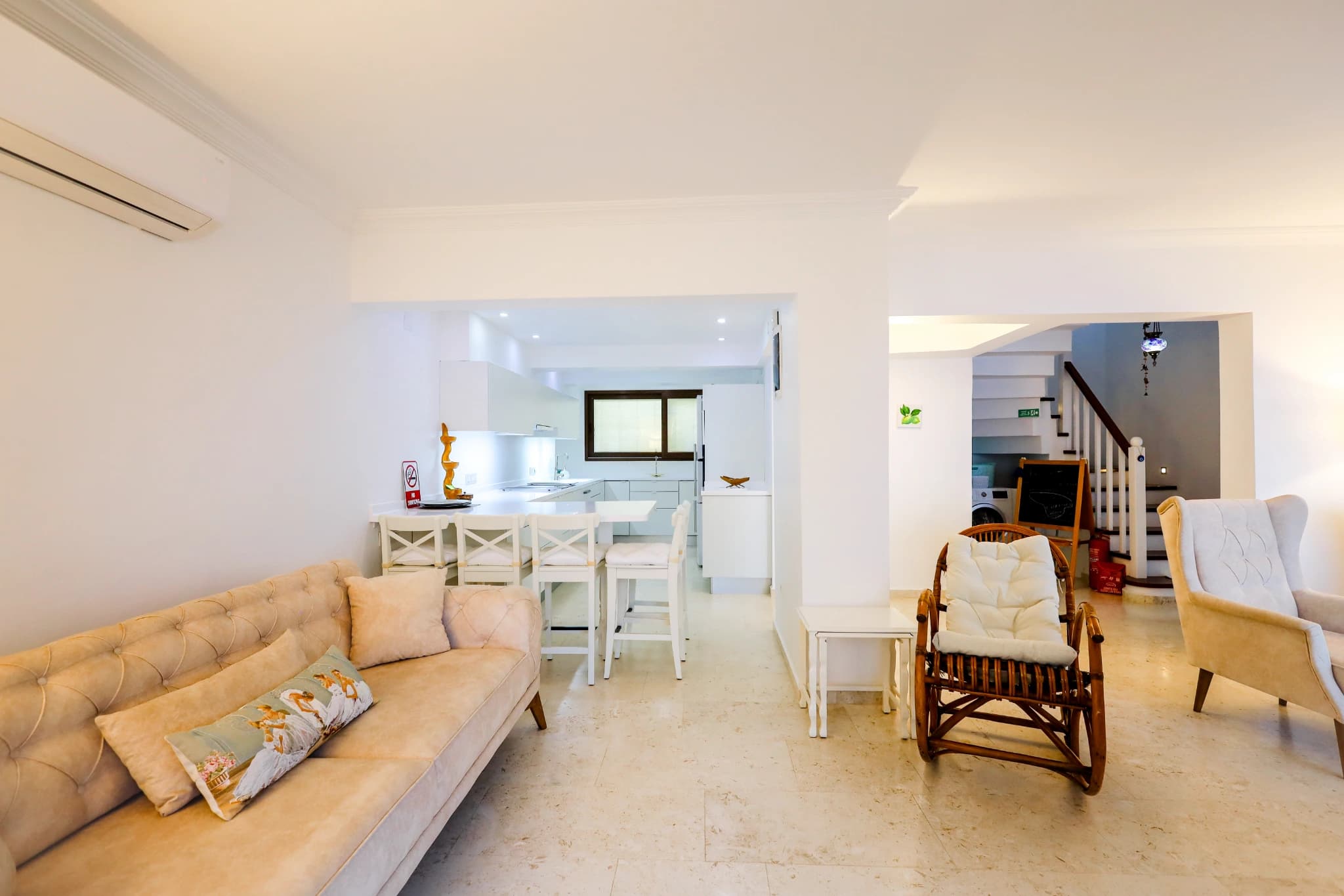 Open-plan living and dining area with kitchen visible in background.