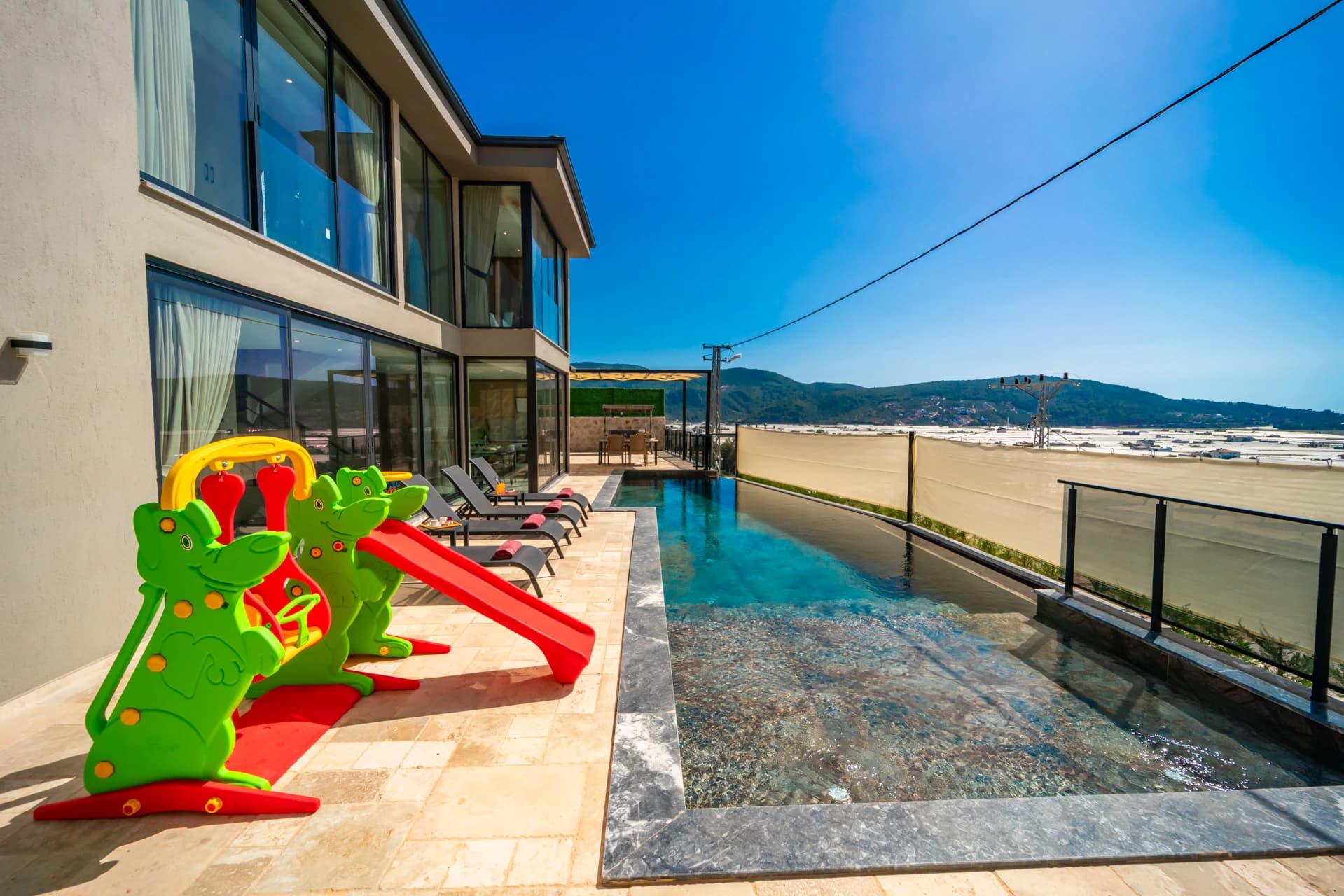 Expansive terrace with private pool, lounge chairs, and scenic countryside views.