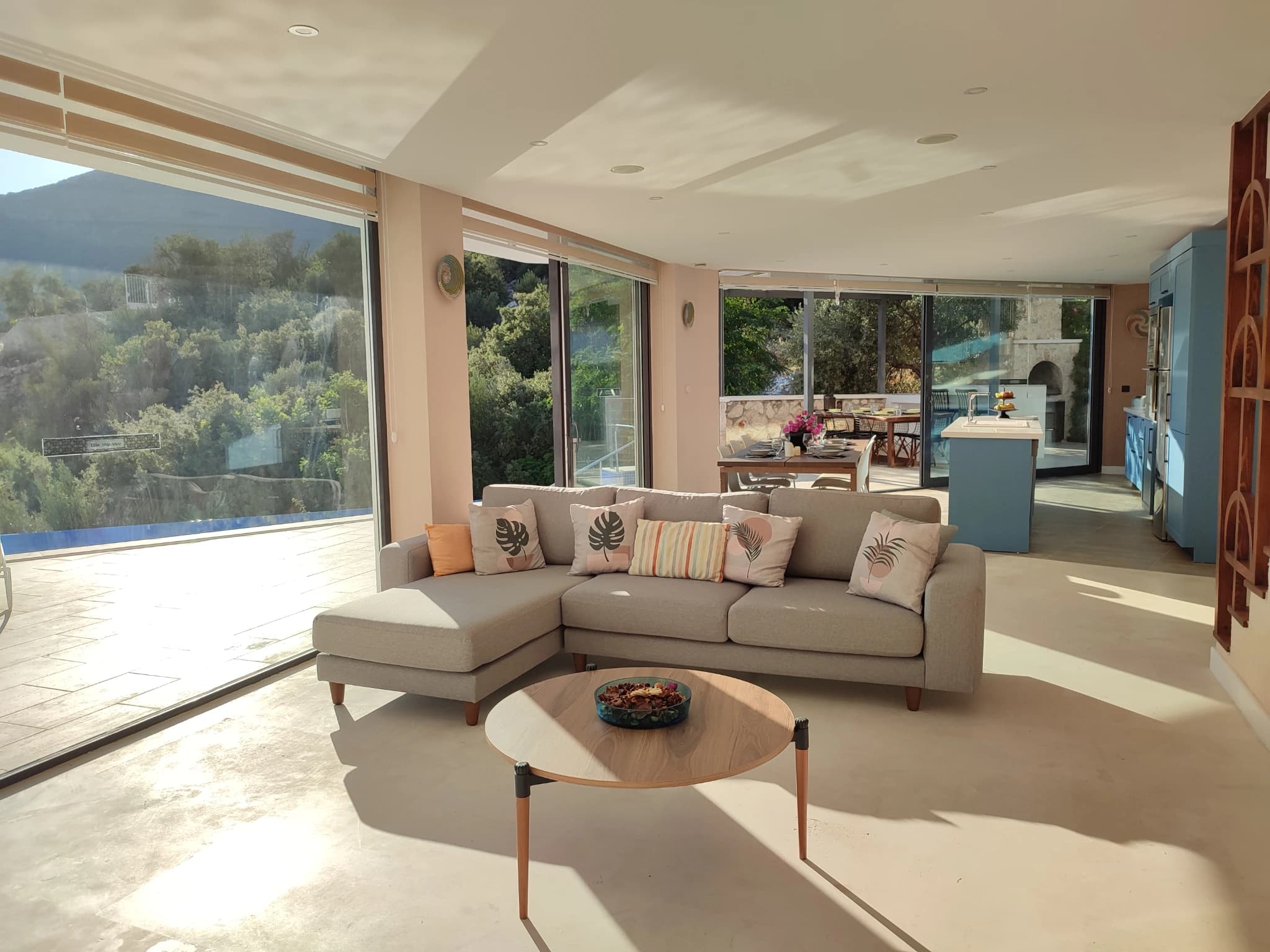 Bright living room with panoramic sea views, modern sectional, and access to terrace.