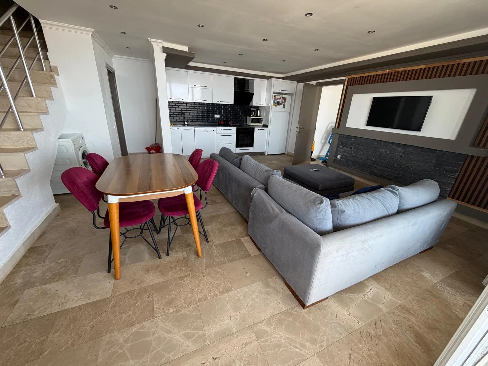 Open-plan living and dining area with modern furnishings and integrated kitchen.
