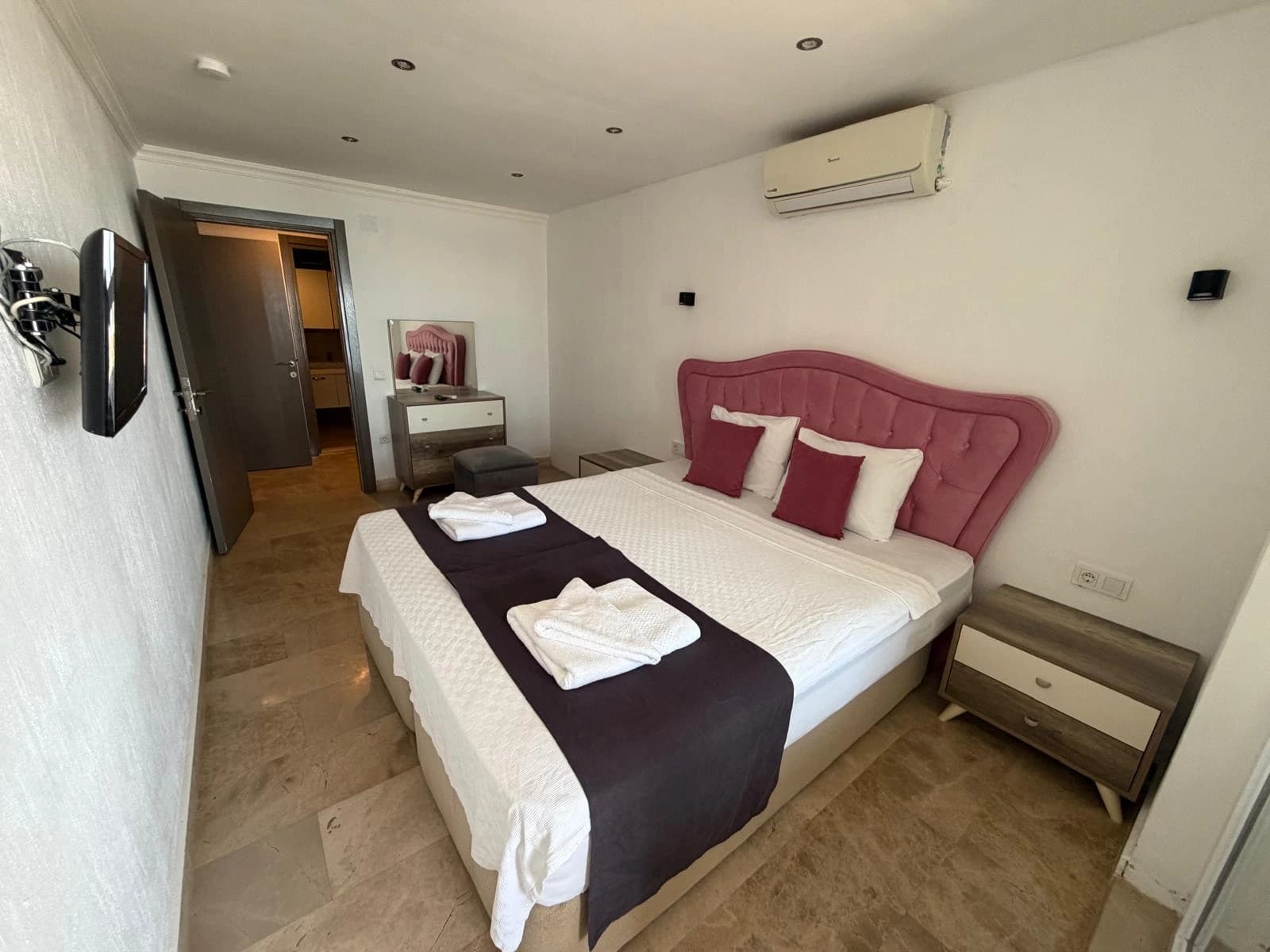 Comfortable bedroom with king bed, AC unit, and ensuite access.