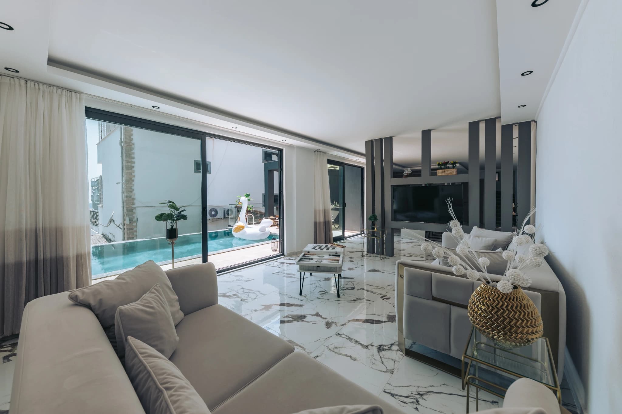Living room with direct access to private pool and panoramic sea views through floor-to-ceiling windows.