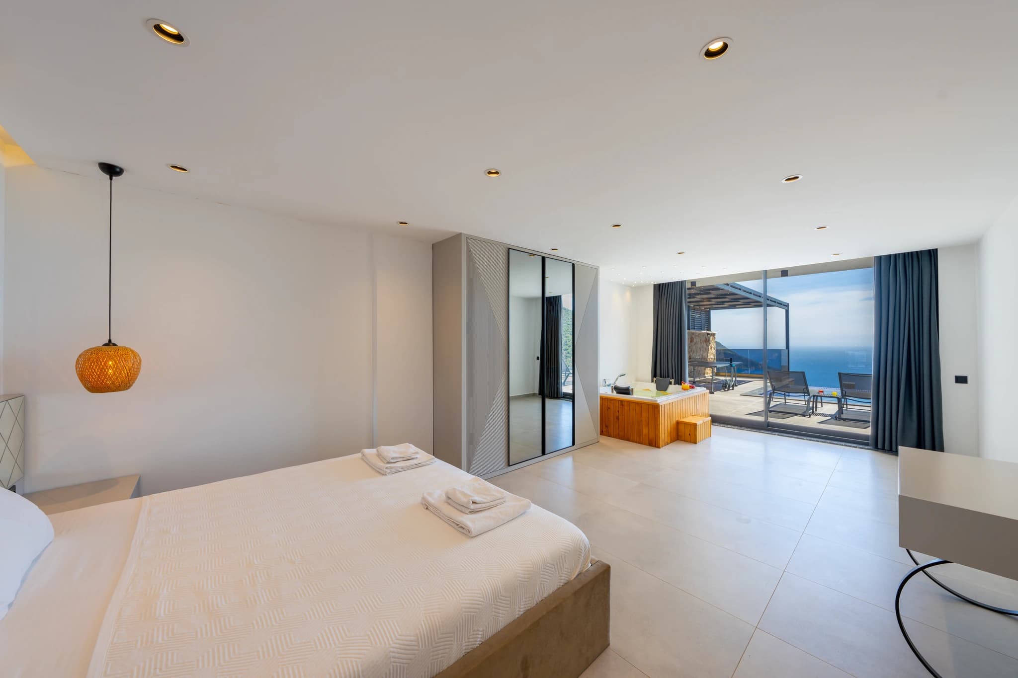 Spacious master bedroom with a double bed, ensuite bath, and direct access to sea-view terrace.