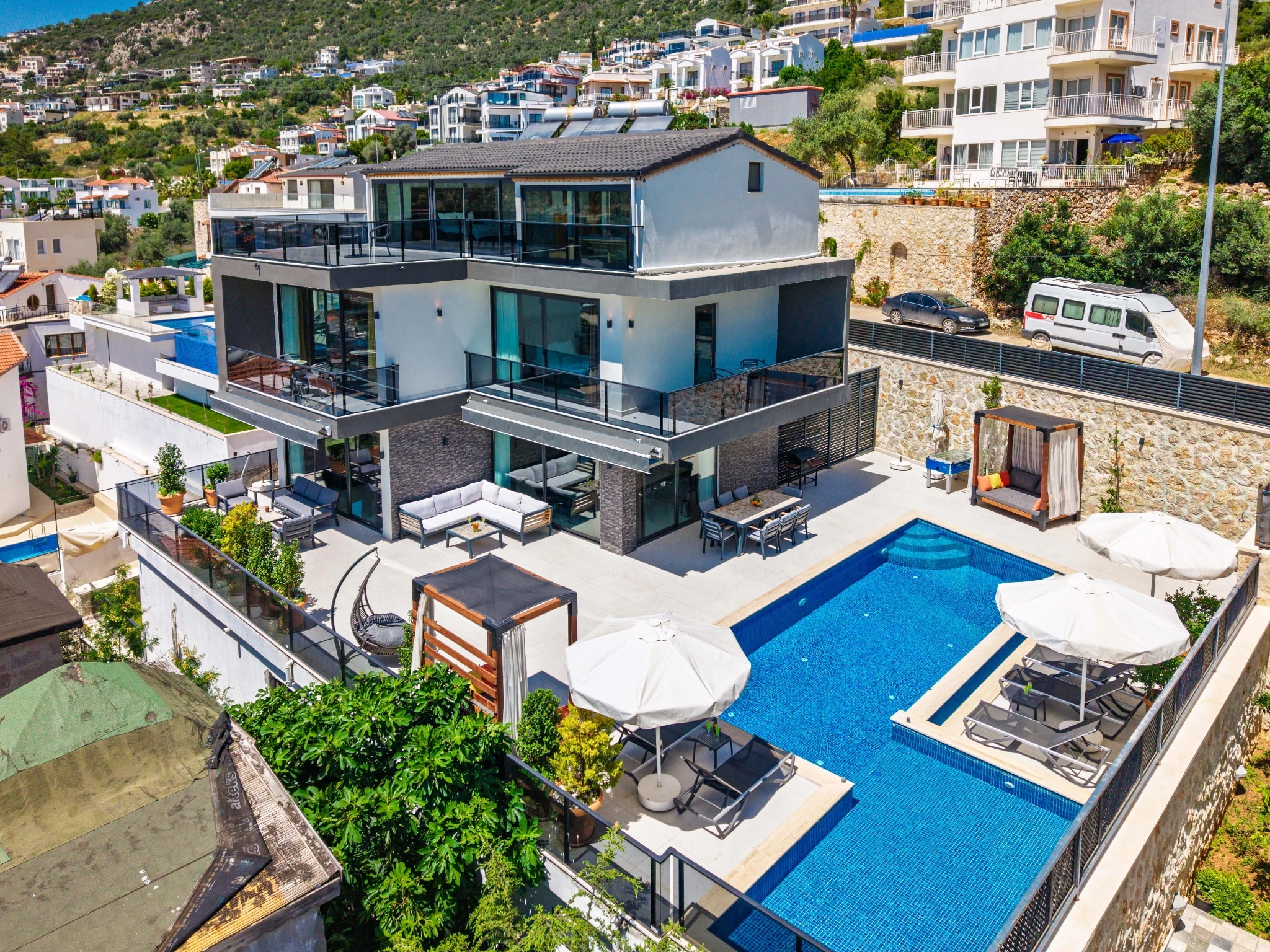 Aerial view of villa featuring two pools, lounging areas, and landscaped garden.