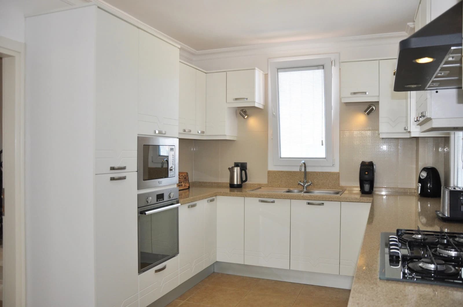 Kitchen corner view showing cooking area with window and storage.