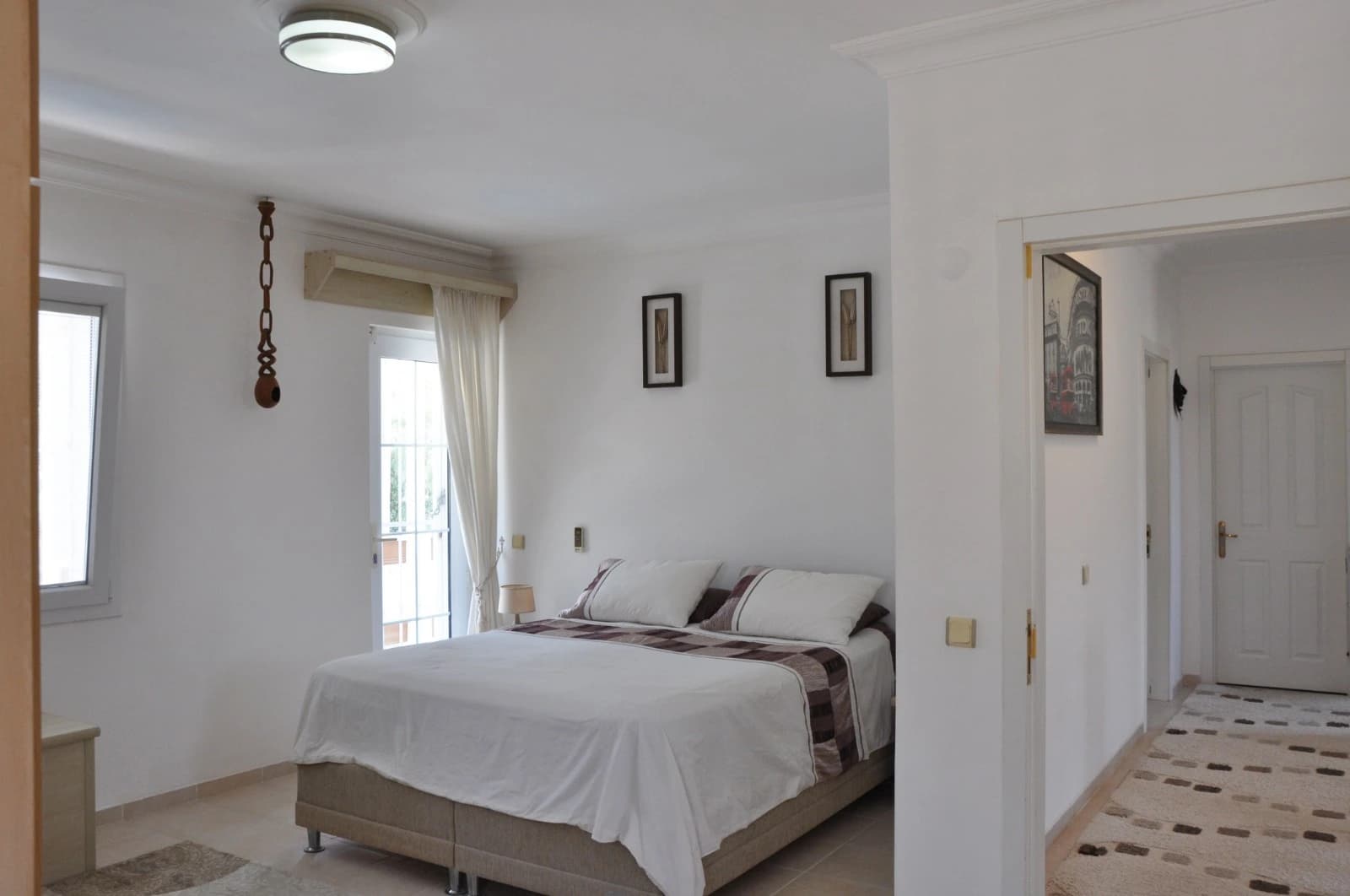 Bright bedroom with balcony access and natural light.