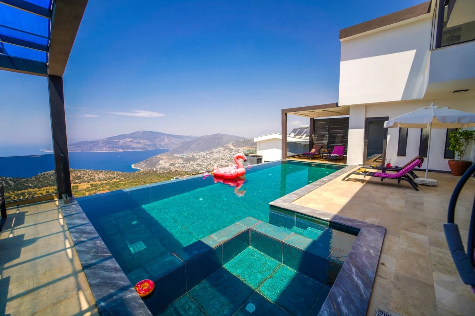 Stunning infinity pool with breathtaking sea and mountain vistas, floats included.