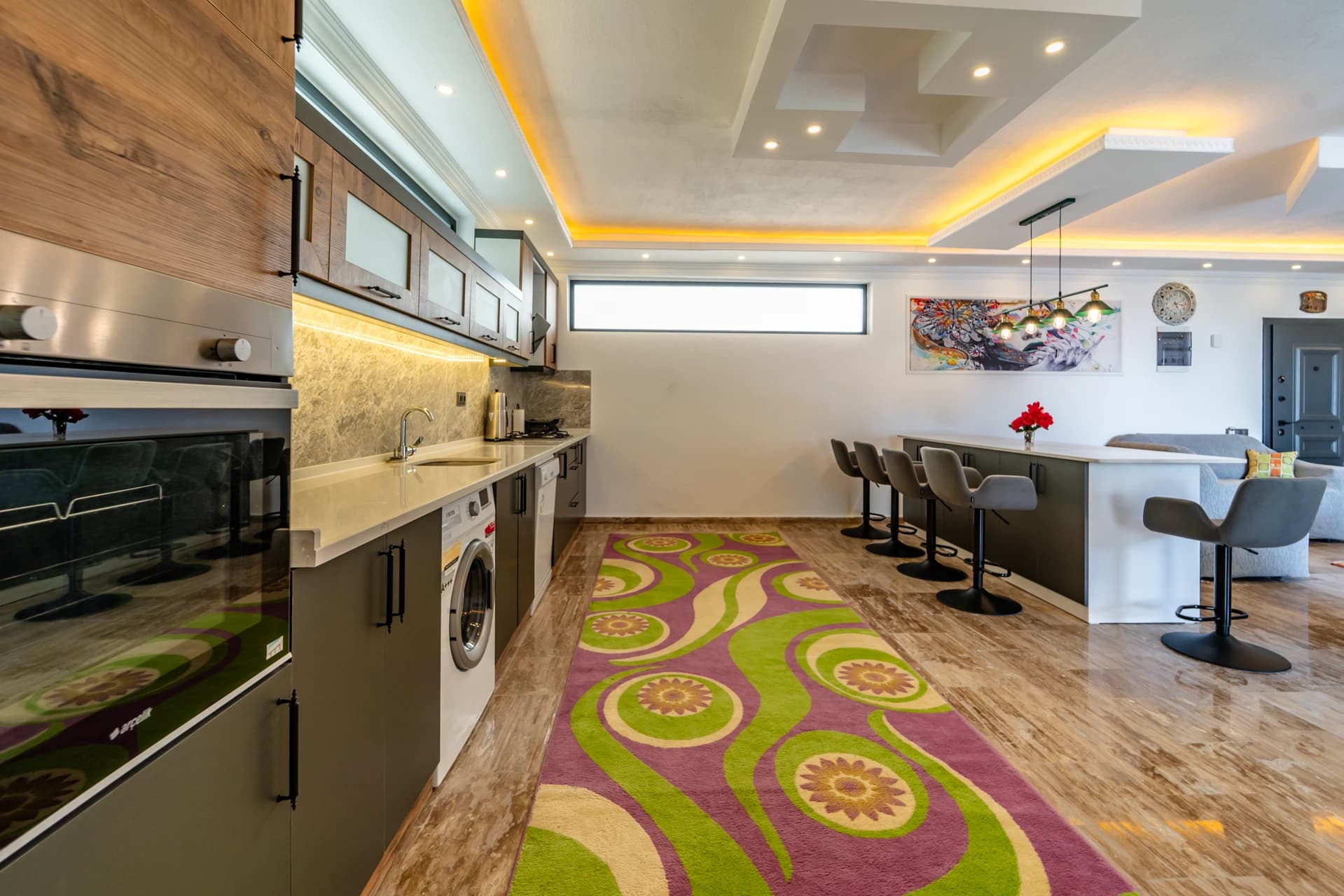 Modern kitchen with full appliances including dishwasher, oven, and washer.