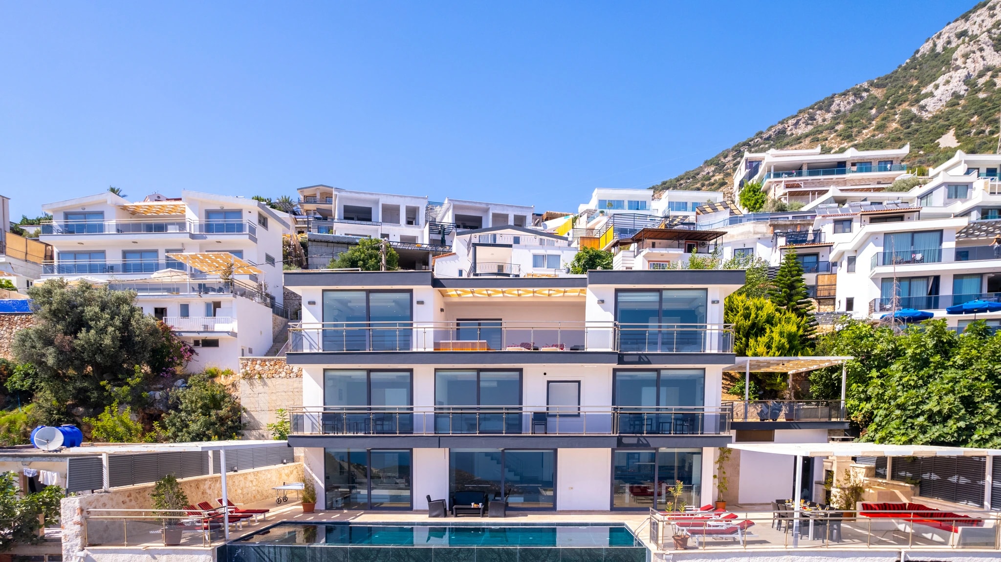 Modern hillside villa with private pool, sun loungers, and expansive sea views.