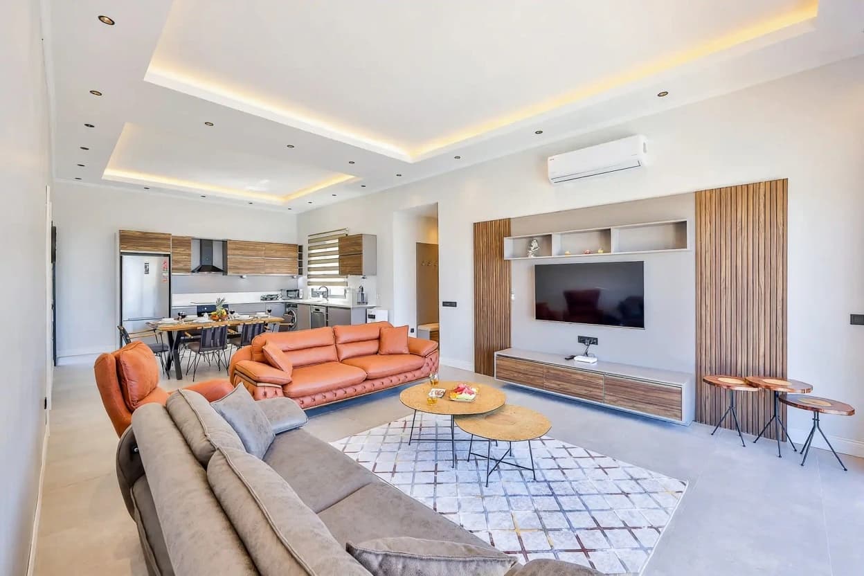 Modern integrated living and kitchen space with comfortable seating arrangements, entertainment center, and seamless flow.