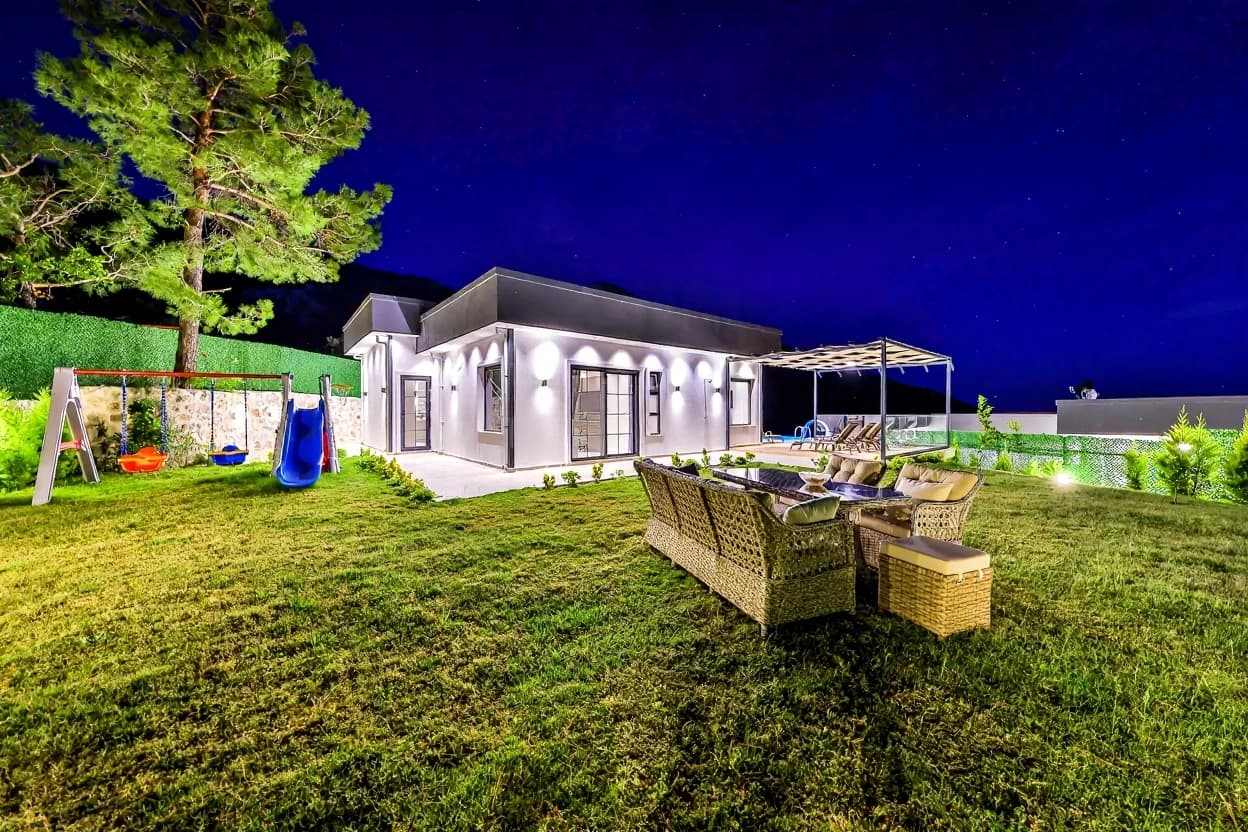 Panoramic garden view with comfortable seating overlooking the entire property at night.