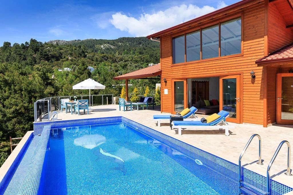 Resort-style private pool with loungers and mountain backdrop.