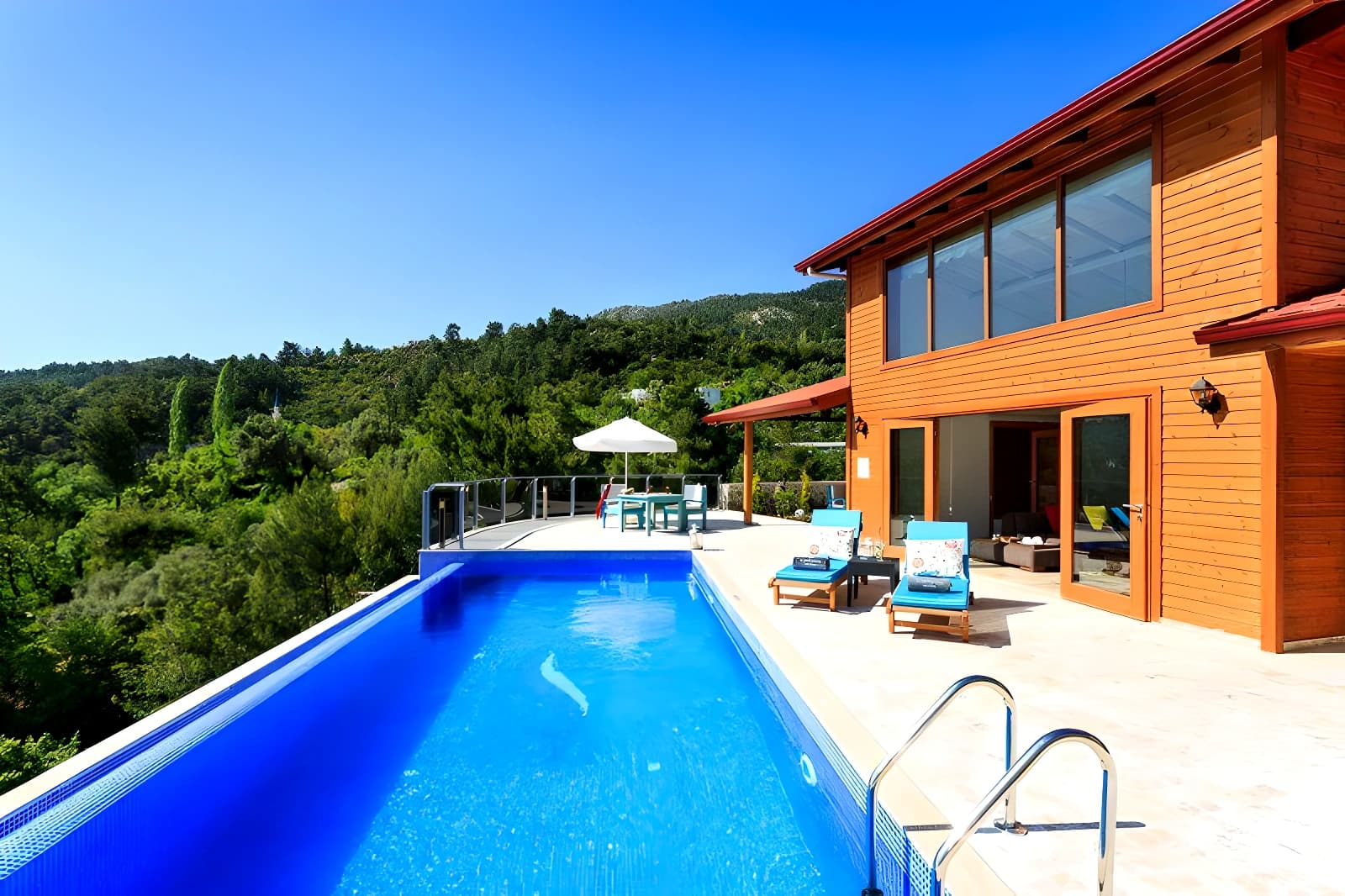 Resort-style infinity pool overlooking lush gardens and mountain landscape.