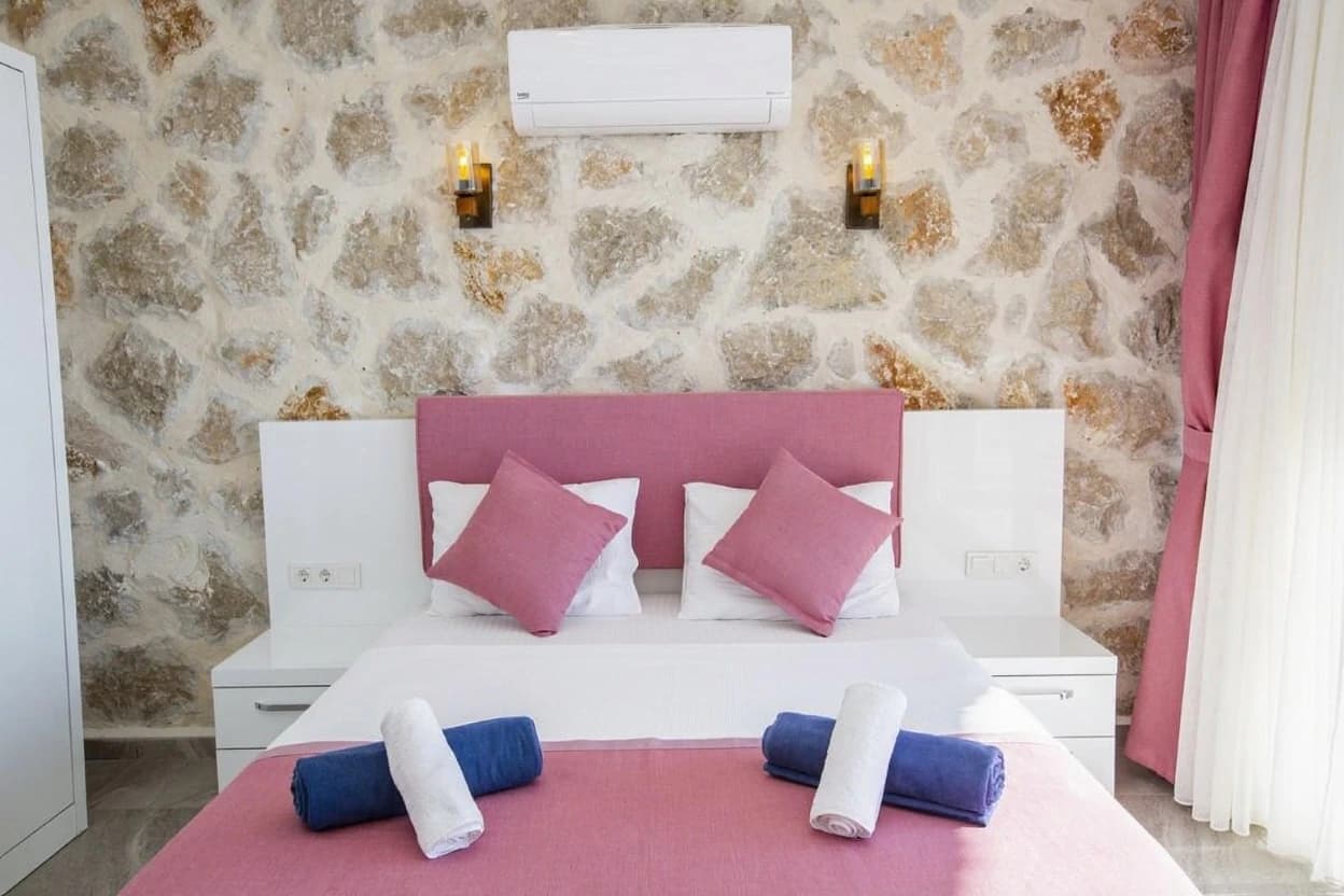 Twin bedroom with charming stone walls and modern amenities.