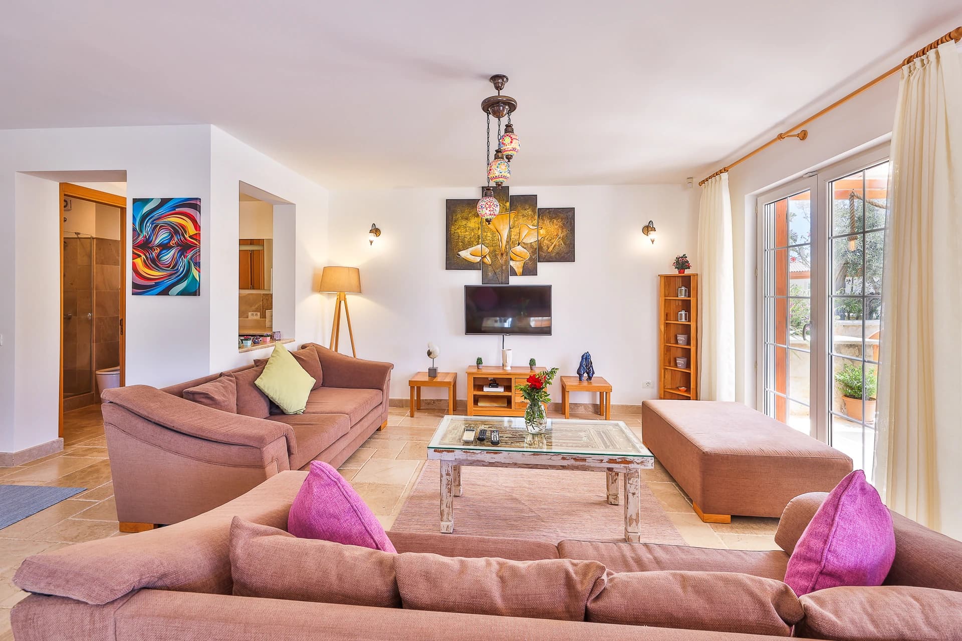 Spacious living room with multiple seating areas and large patio doors opening to outdoor space.