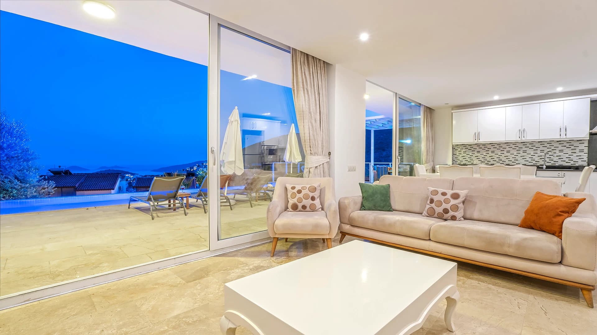 Stunning twilight terrace view overlooking the sea with outdoor seating.