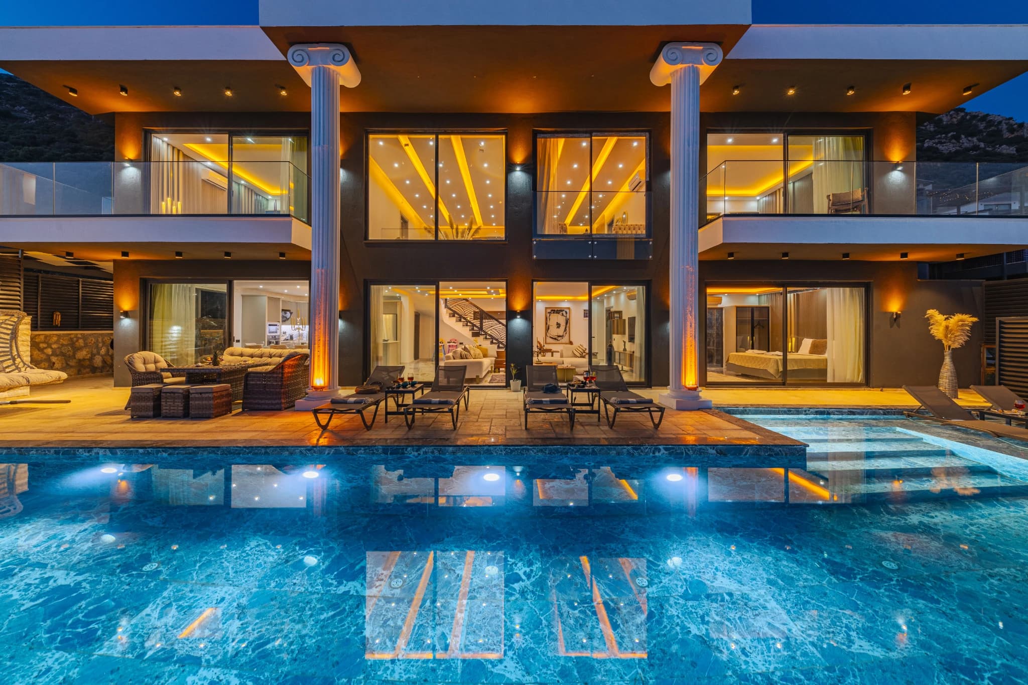 Expansive pool with outdoor seating and floor-to-ceiling windows overlooking the valley.