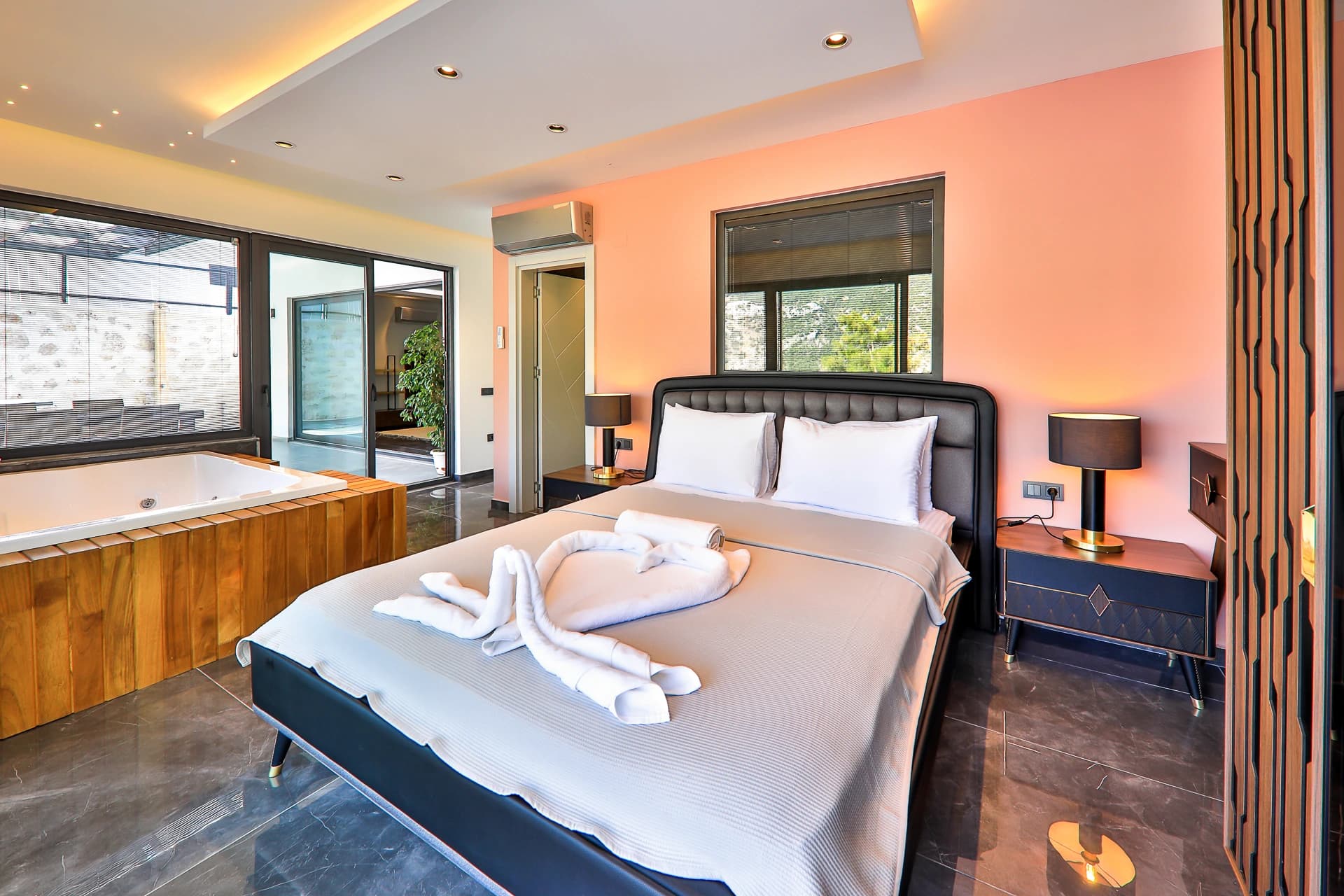 Luxurious master bedroom with a double bed, in-room jacuzzi tub, and spa-like ensuite bathroom.