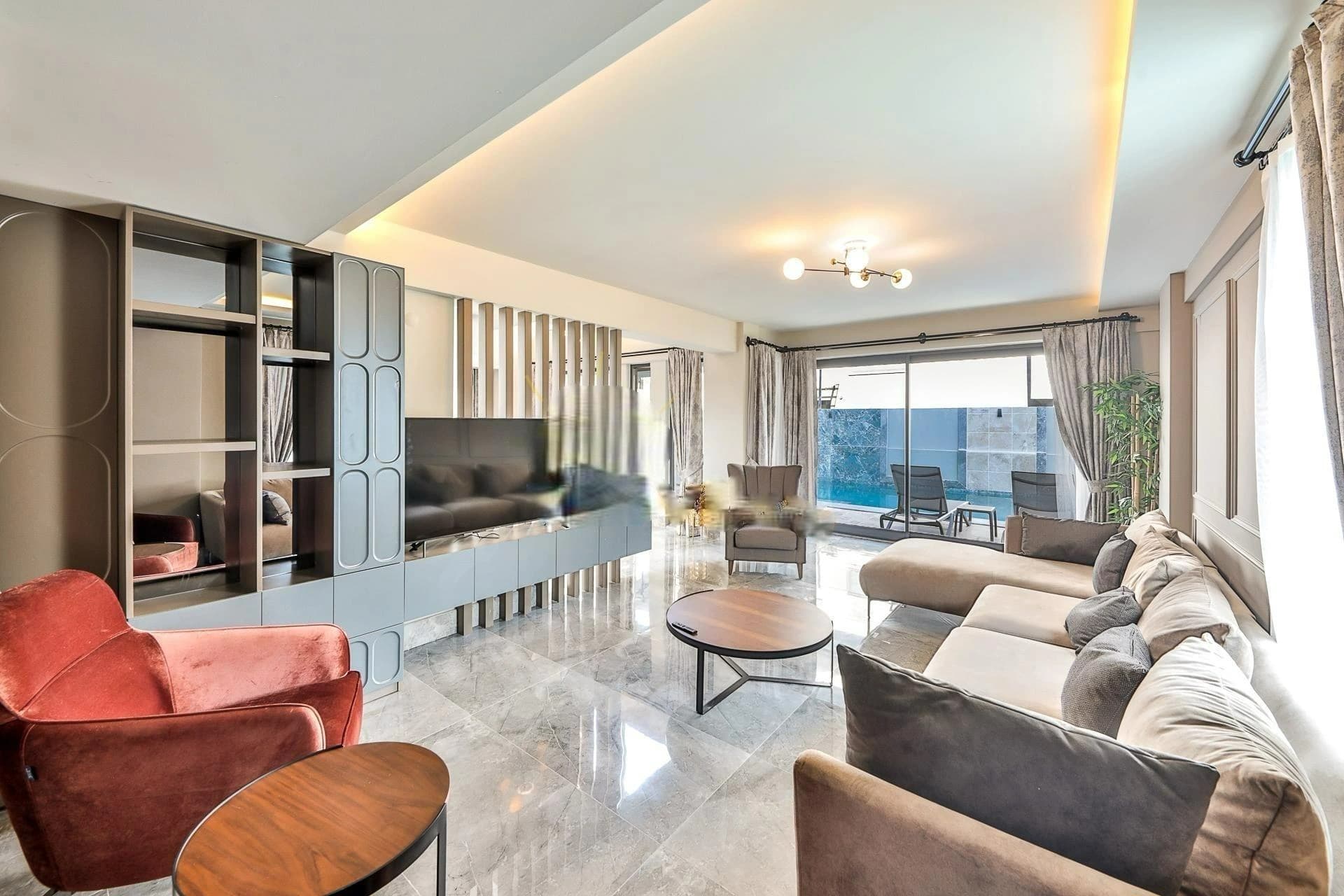 Spacious living room with modern seating and access to balcony with sea views.