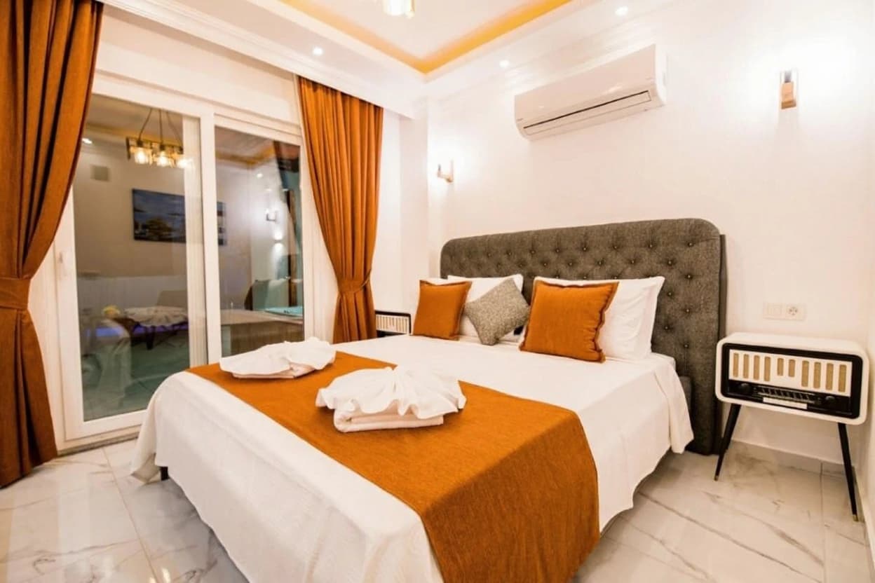 Spacious modern bedroom with comfortable double bed and contemporary furnishings.