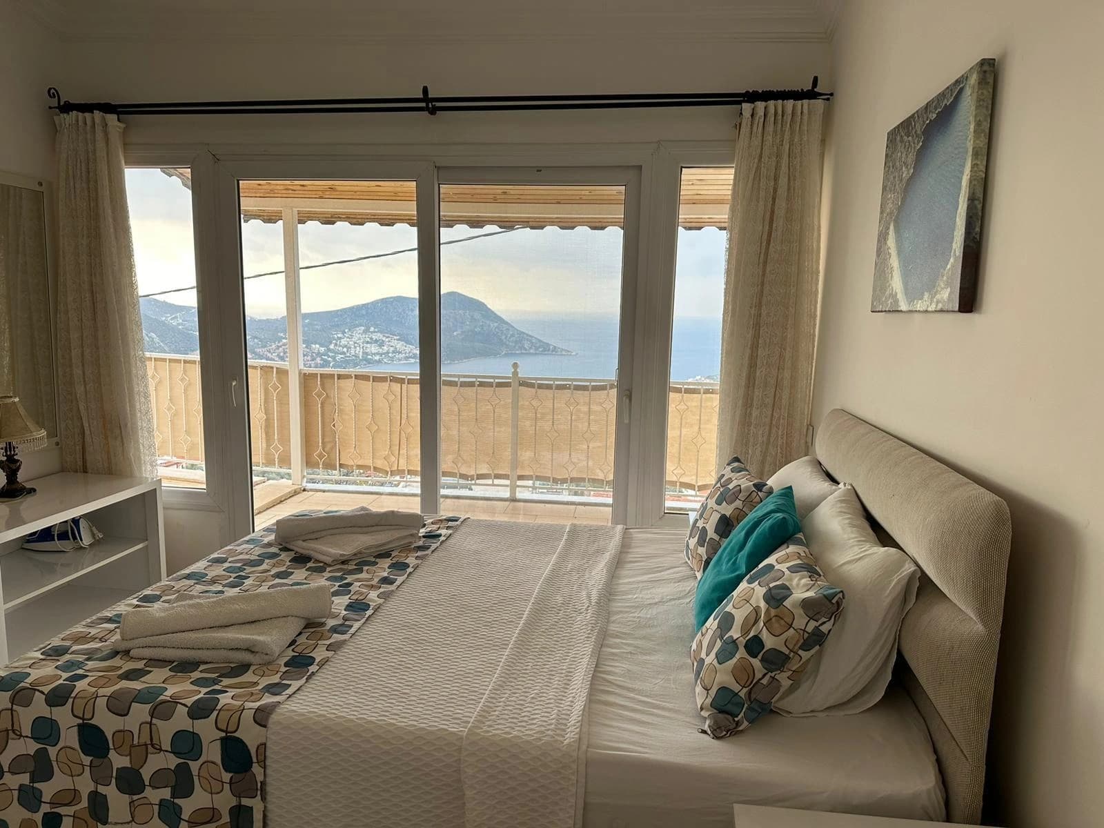 Scenic bedroom with twin beds and panoramic coastal views from the private balcony.