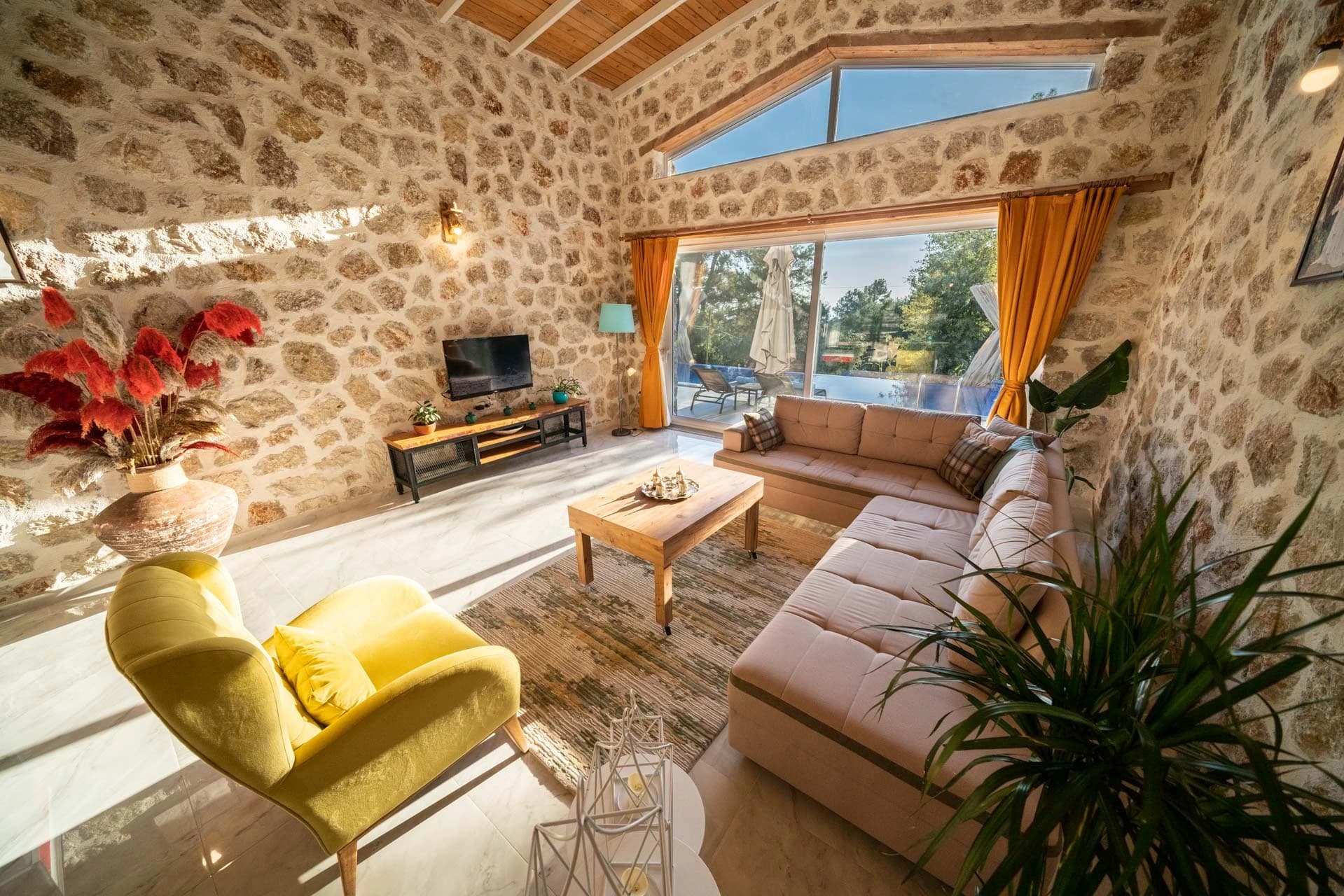 Modern living room with comfortable seating, fireplace, and garden views.