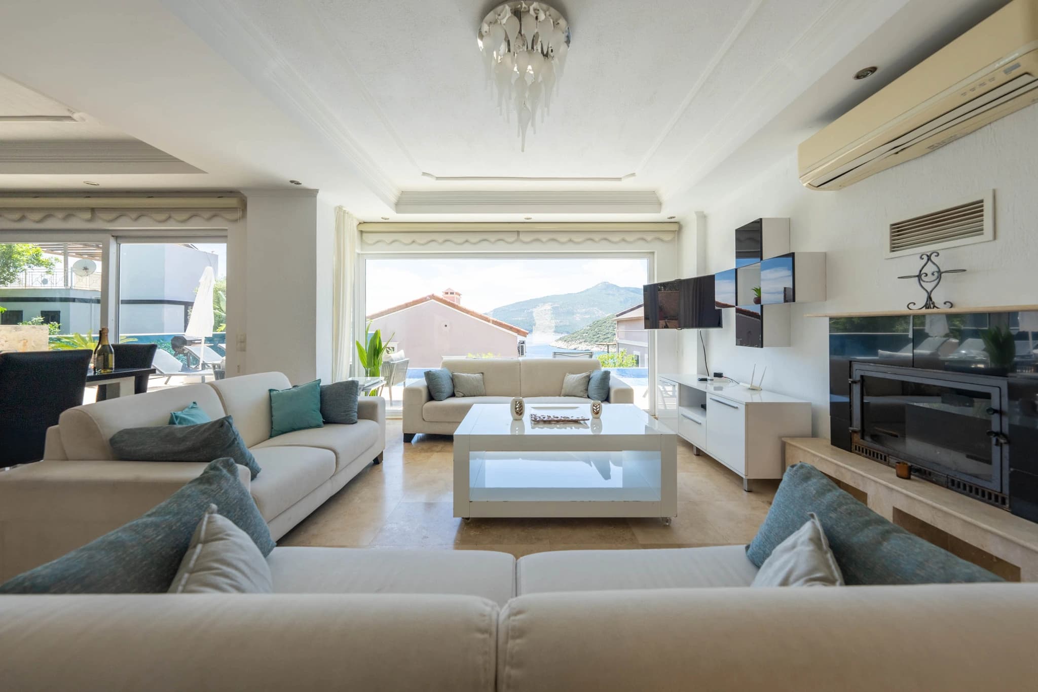 Spacious living room with comfortable seating, fireplace, and panoramic sea views.