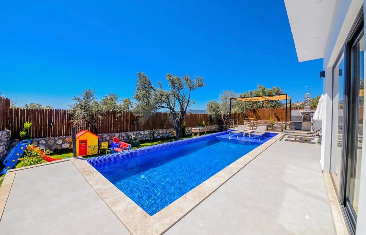 Spacious swimming pool with child-friendly features and lounging areas in bright daylight.