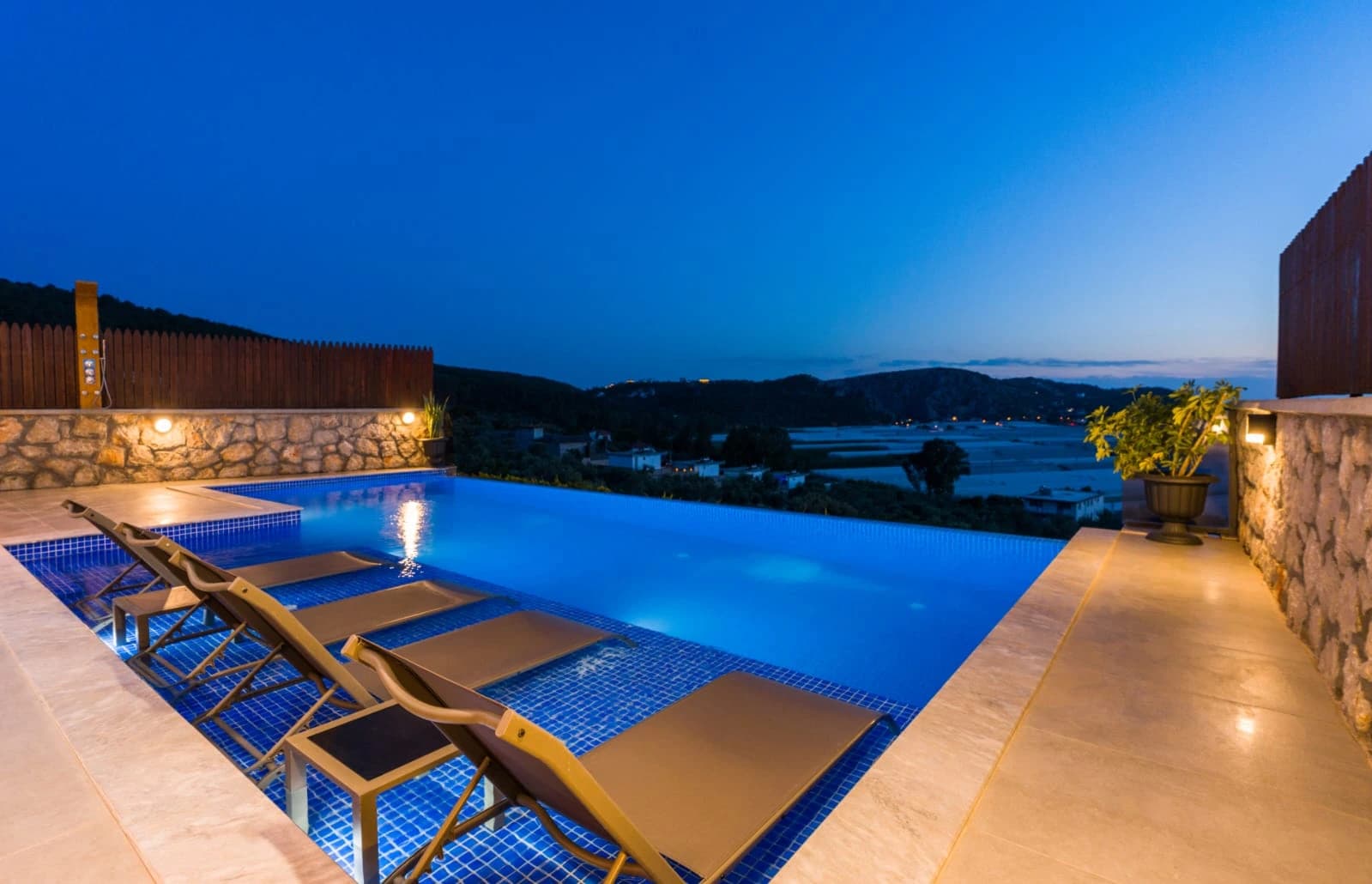 Spectacular illuminated infinity pool with panoramic water and mountain views.
