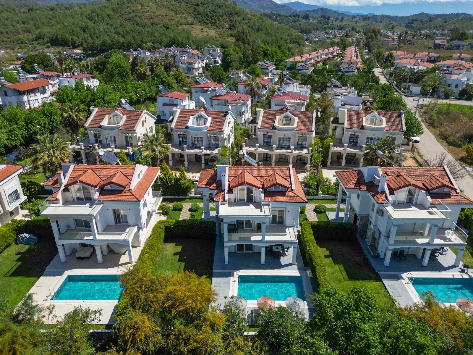 Aerial view of the modern villa complex with pools and manicured grounds in a resort community.