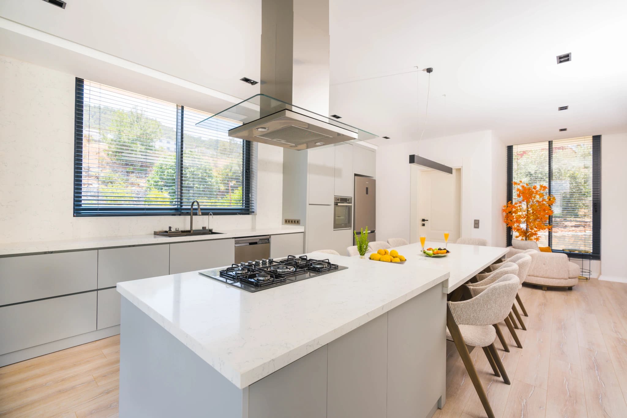 Modern kitchen with central island, gas cooktop, and integrated dining area.