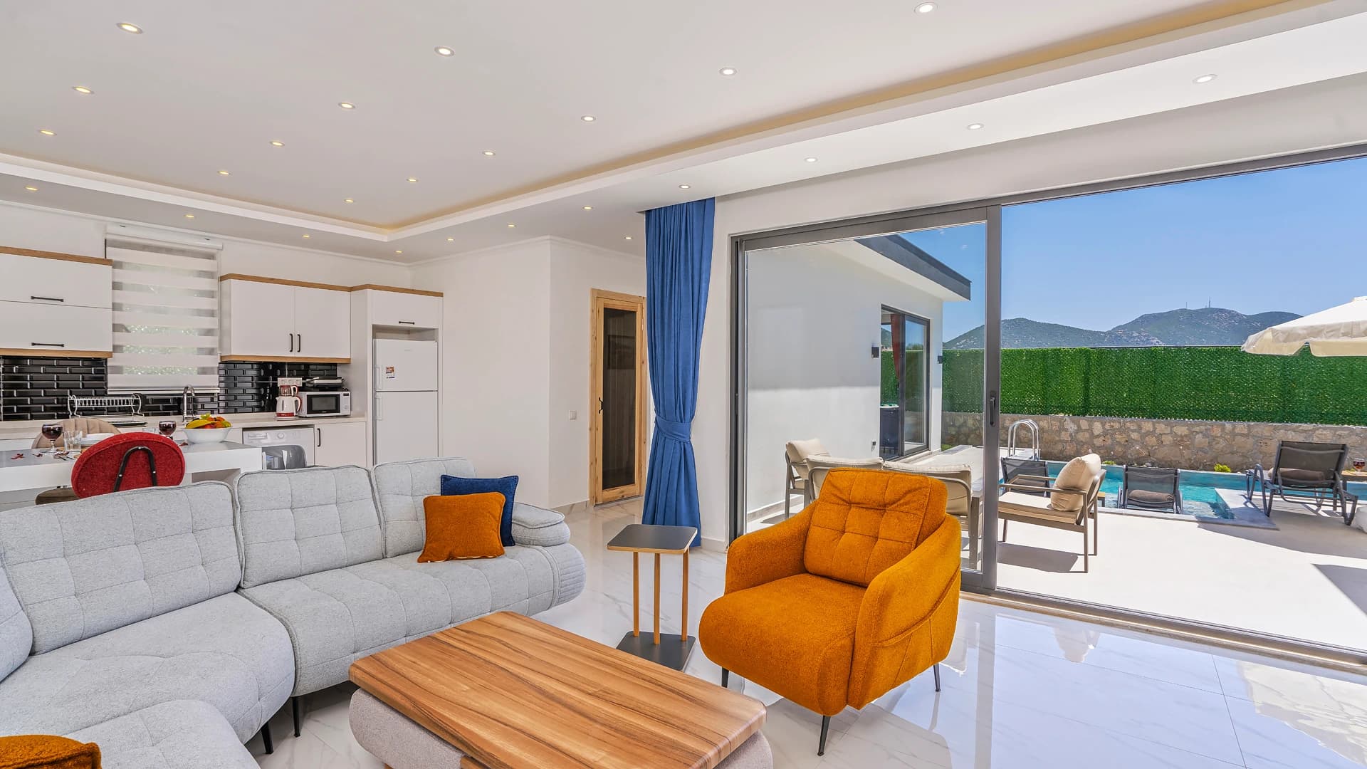 Open-plan living and kitchen space with modern furnishings and direct pool access.
