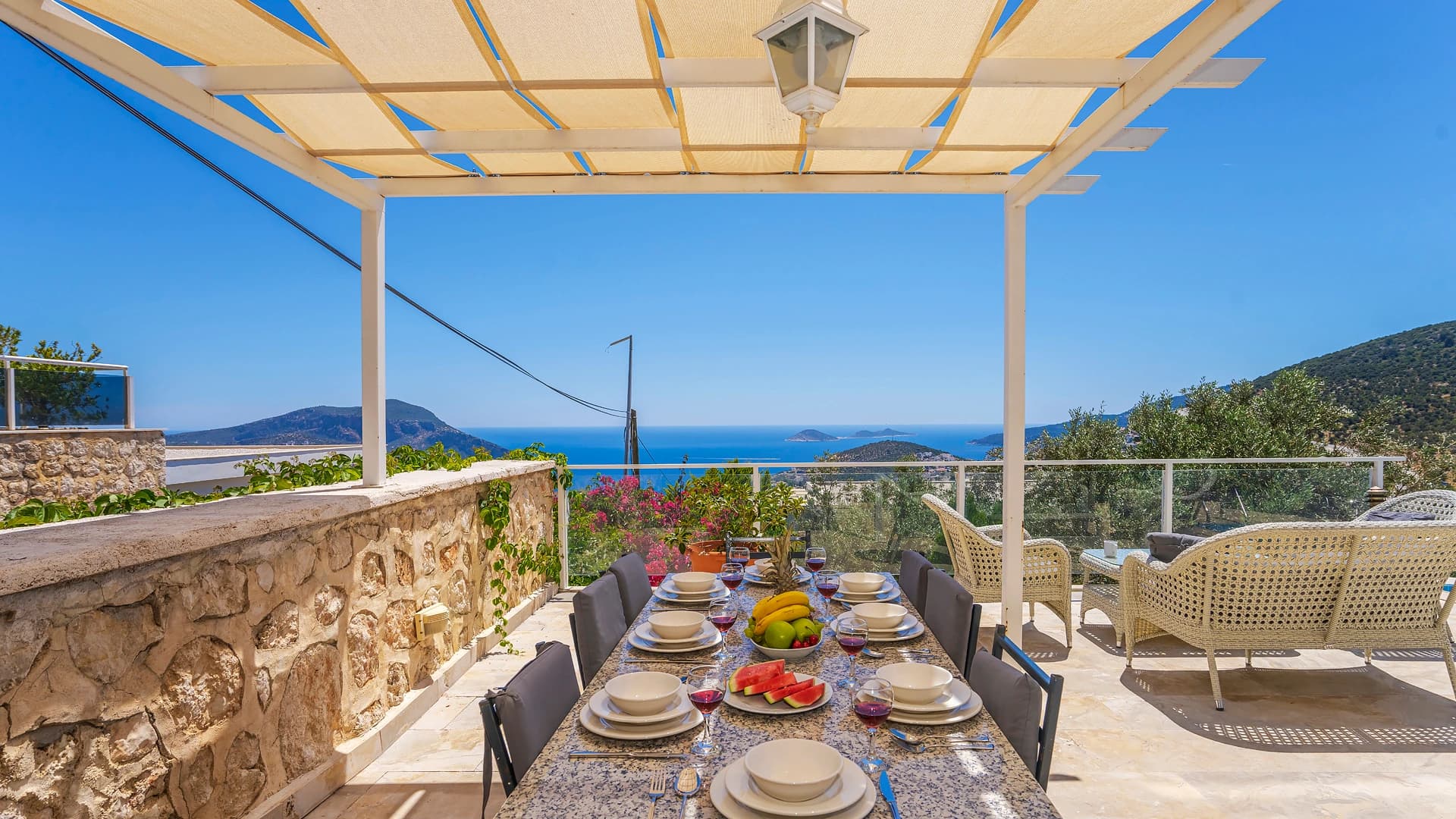 Elevated terrace with outdoor dining setup, panoramic sea views, and modern pergola.