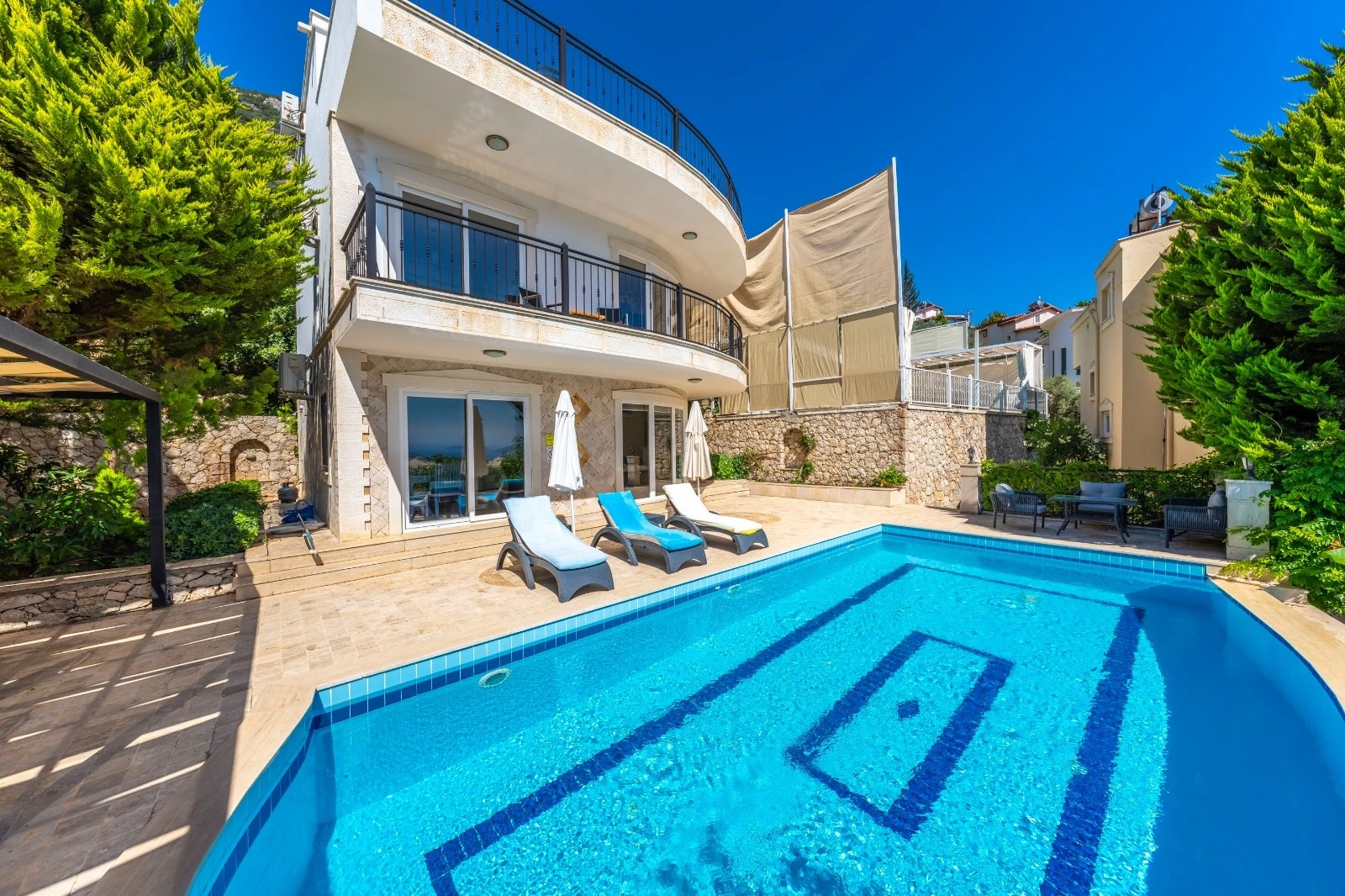 Private swimming pool with sun loungers and sea views from the villa terrace.