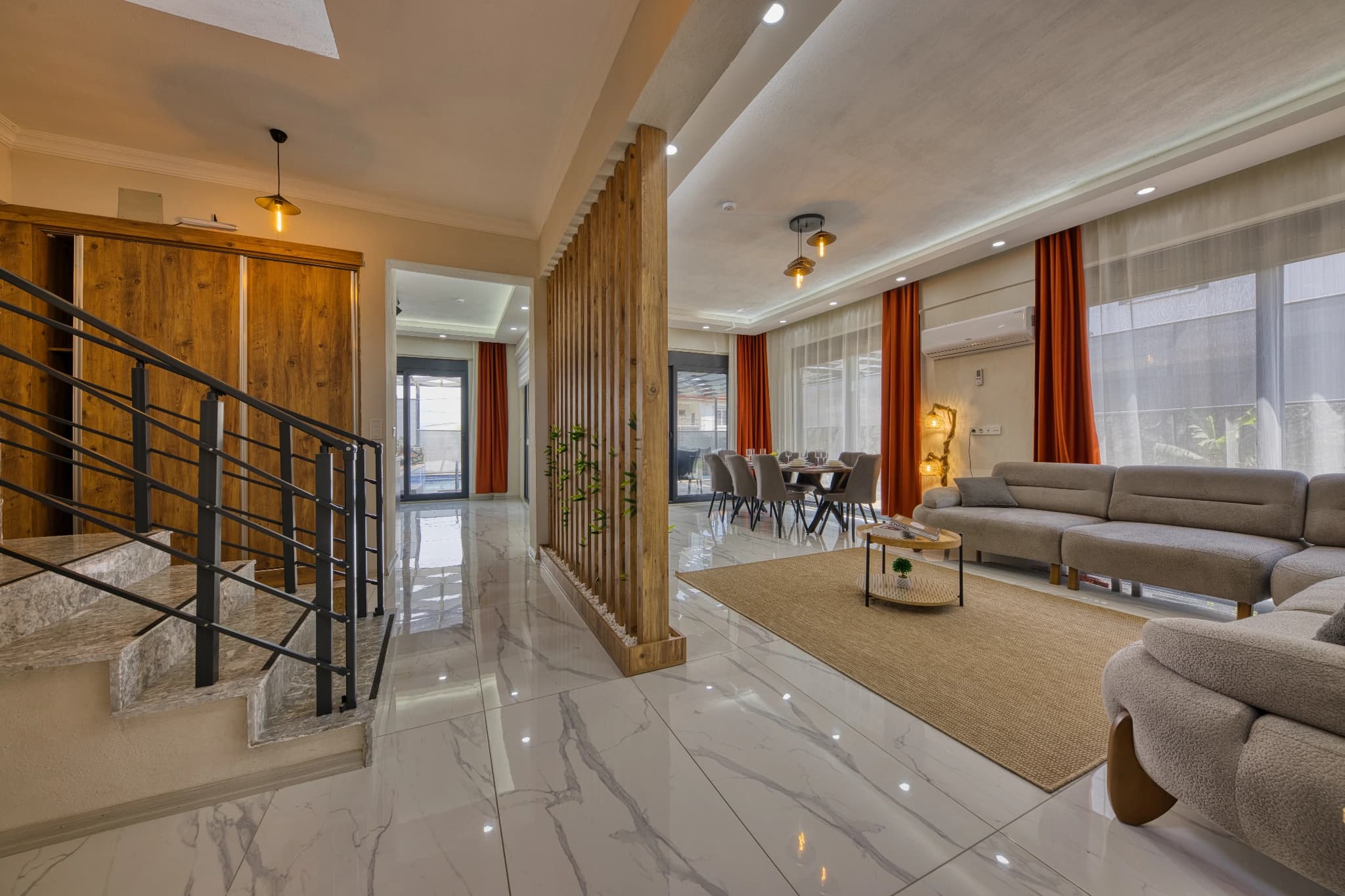 Spacious open-plan living area with sofa, dining zone, and modern decor.