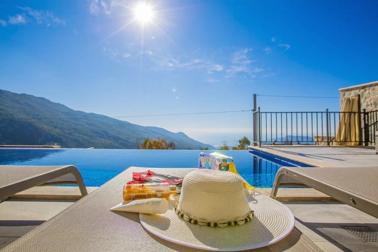Inviting pool area with loungers and panoramic views of verdant mountains.