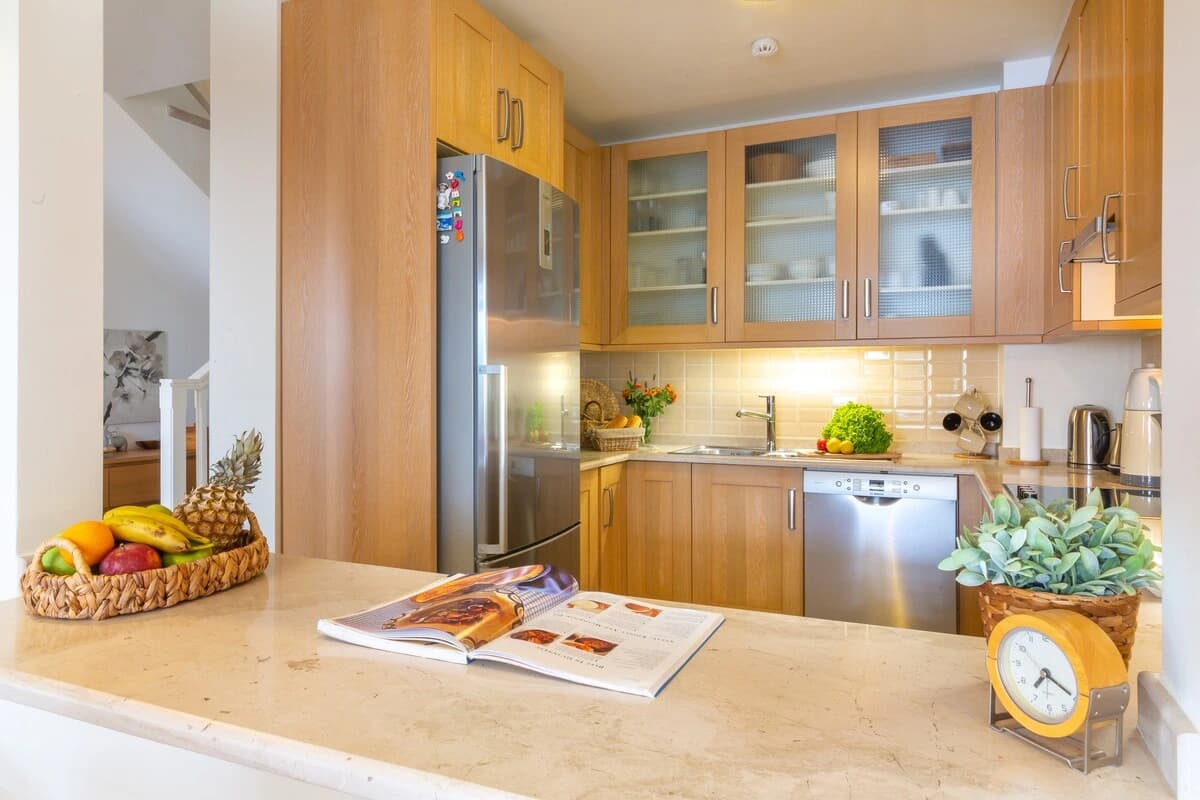 Bright kitchen with wooden cabinetry, island counter, and modern appliances.