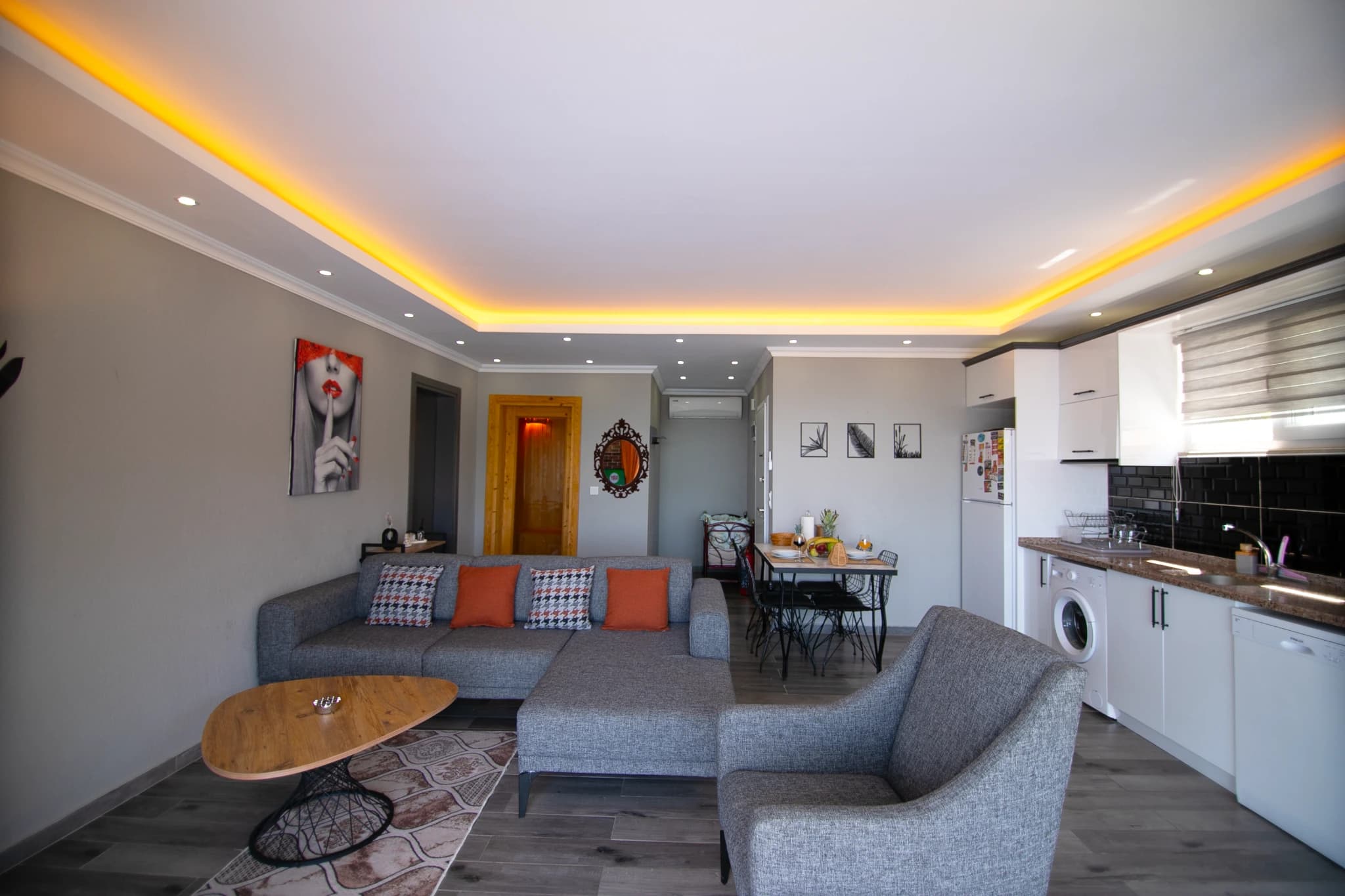 Full view of modern living and dining area with contemporary furnishings and mood lighting.