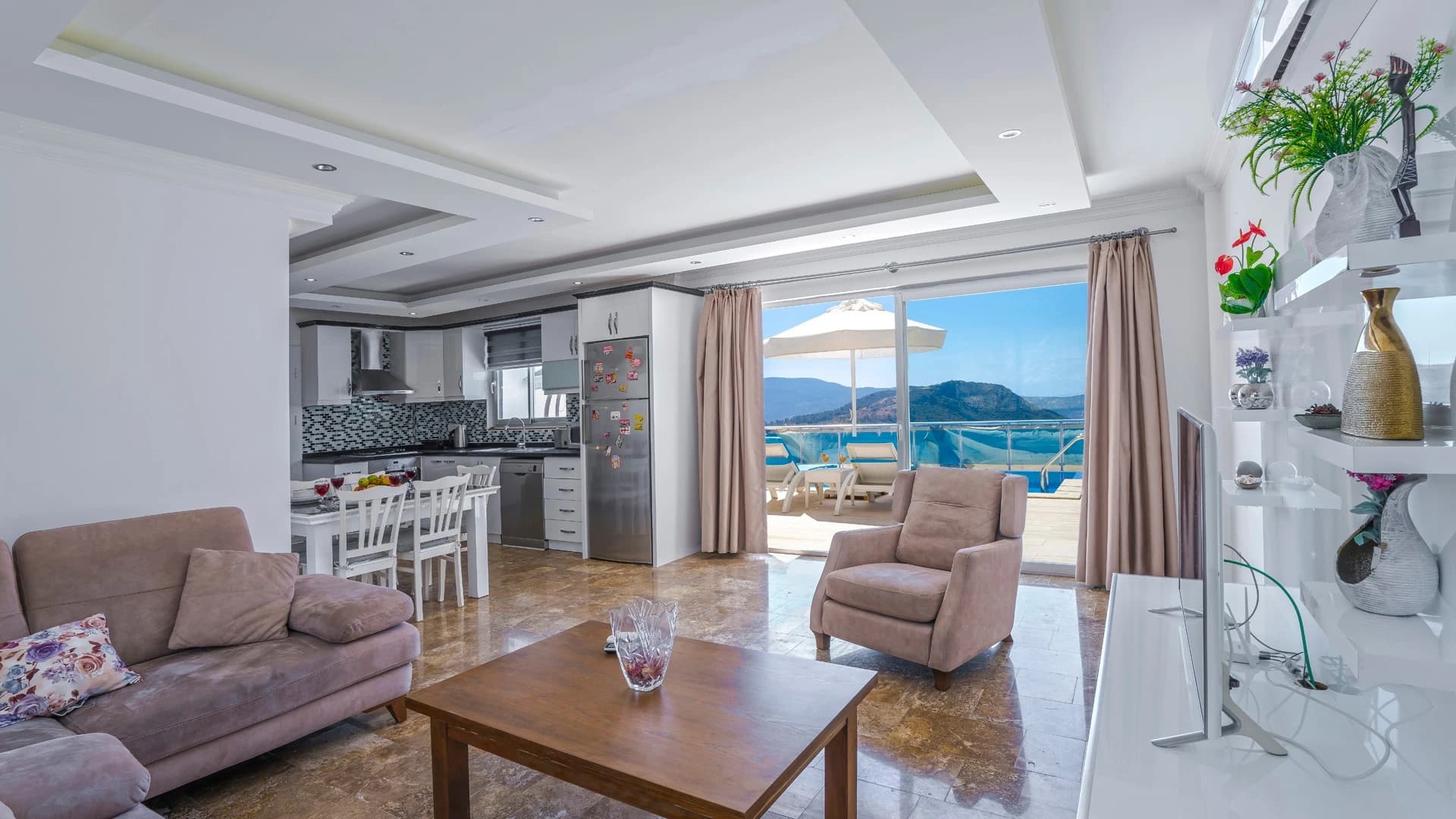 Secluded Nature Retreat Villa with Heated Pool and Sea & Mountain Views in Kalkan – Spacious open-plan living room with sofas, sea and mountain views through large windows.