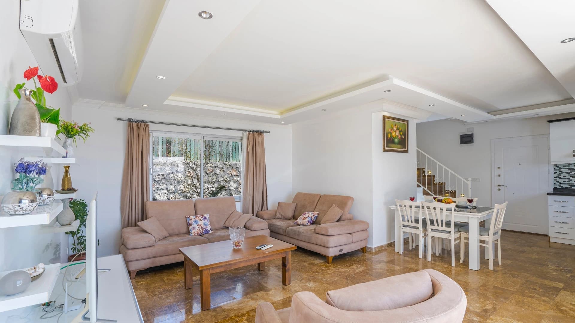 Secluded Nature Retreat Villa with Heated Pool and Sea & Mountain Views in Kalkan – Bright living room with two sofas, dining area, and staircase access to upper floor.